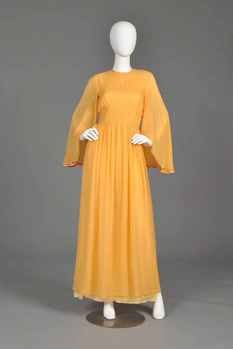Beautiful 1970s Hanae Mori silk chiffon gown. Absolutely stunning piece! Pale sherbet color with high neck + draped full skirt. MASSIVE tiered, silk chiffon draped sleeves with silk piping. Smocked waistline with attached silk sash. Fully lined