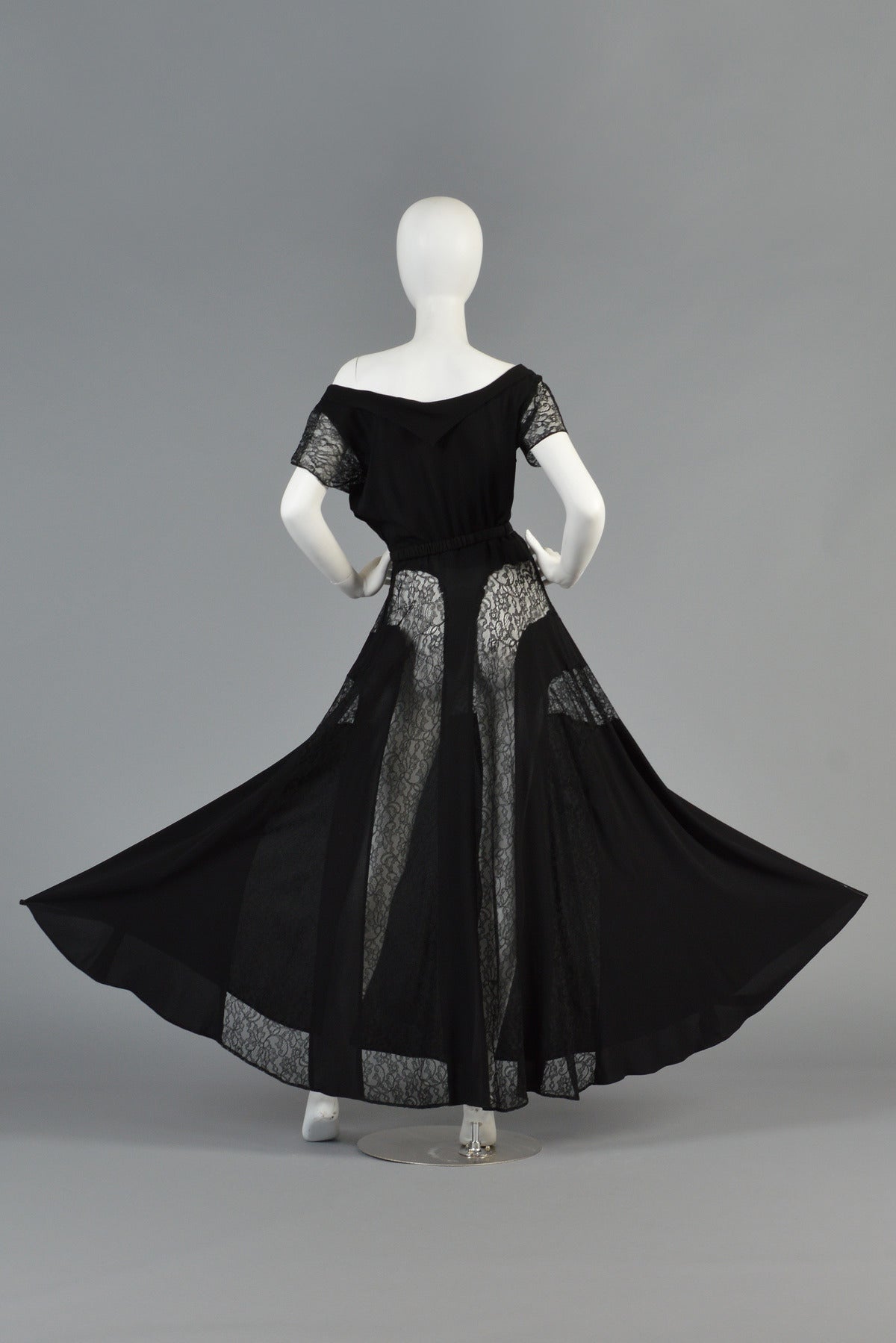 Beautiful 1940's black rayon crepe evening dress with lace inserts. Such a gorgeous piece!

Dress features a wide scoop neck with short lace sleeves and full skirt. Daring sheer lace panels are laid horizontally across the front and fall into