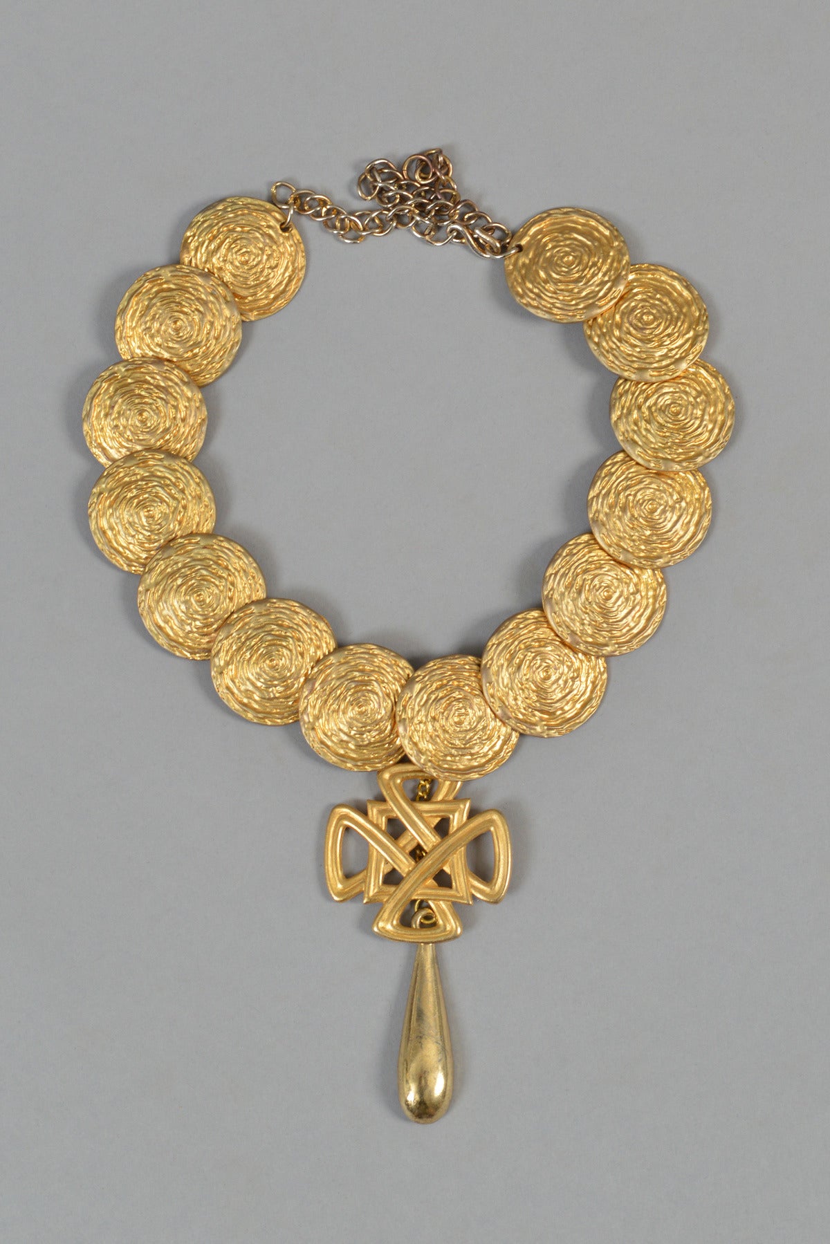 Superb Kenneth Jay Lane oversized gold tone coin necklace with Celtic knot. Adjustable choker length and fits perfectly beneath the collar of a crisp button up shirt. Excellent condition.

MEASUREMENTS
Total Length: 20.5