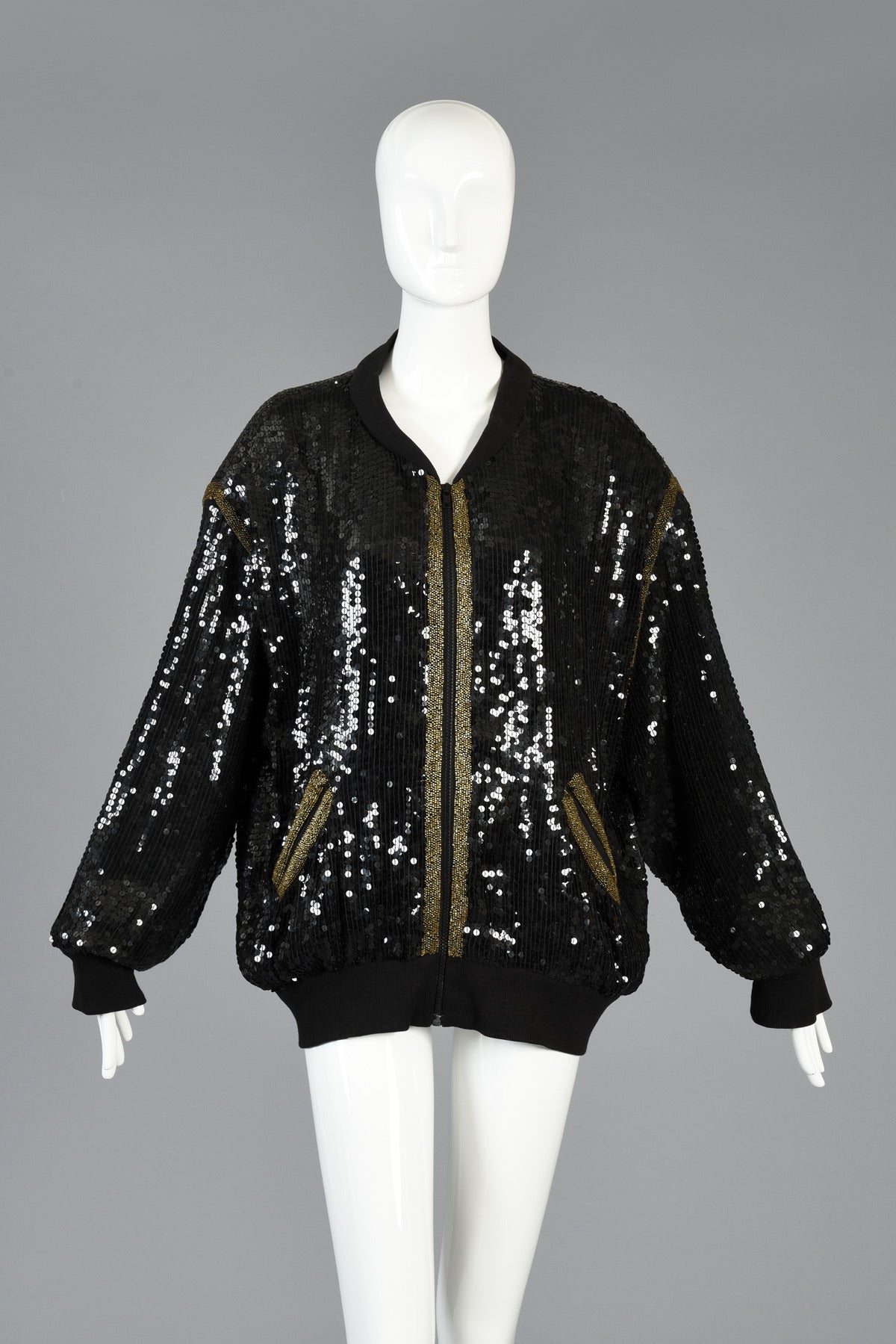 Incredible 1980s fully sequined black silk bomber jacket with massive indian chief head on the back! Gold striping details around the zippered pockets + shoulders. Huge indian head is fully sequined with beaded fringe hanging from the head dress.