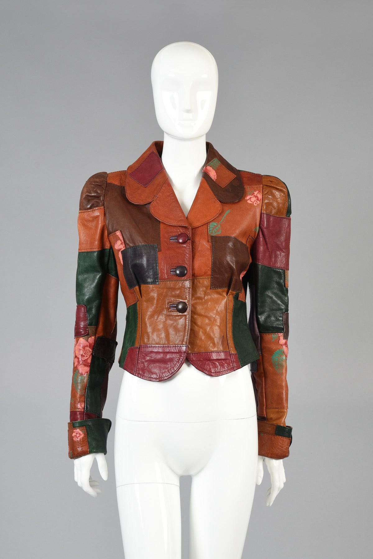 Killer 1970's patchwork leather and roses jacket by Gandalf the Wizard. Super rare and sought after design! Ultra fitted body with super long and slender puffed sleeves. Button front. A plethora of autumnal colors in the patchwork with the Gandalf