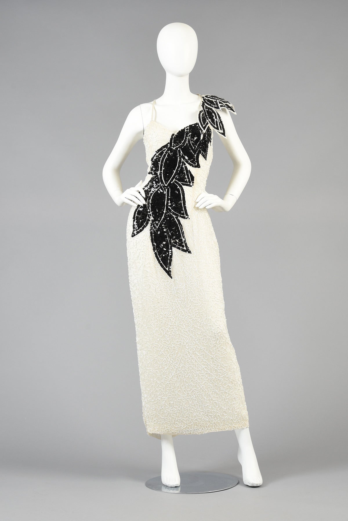 Killer 1980's Lillie Rubin beaded gown. Pale ivory silk body is fully beaded with contrasting black sequin and beaded leaf pattern. Amazing cascading leaves travel asymmetrically across the body with applied architectural leaves around one shoulder.
