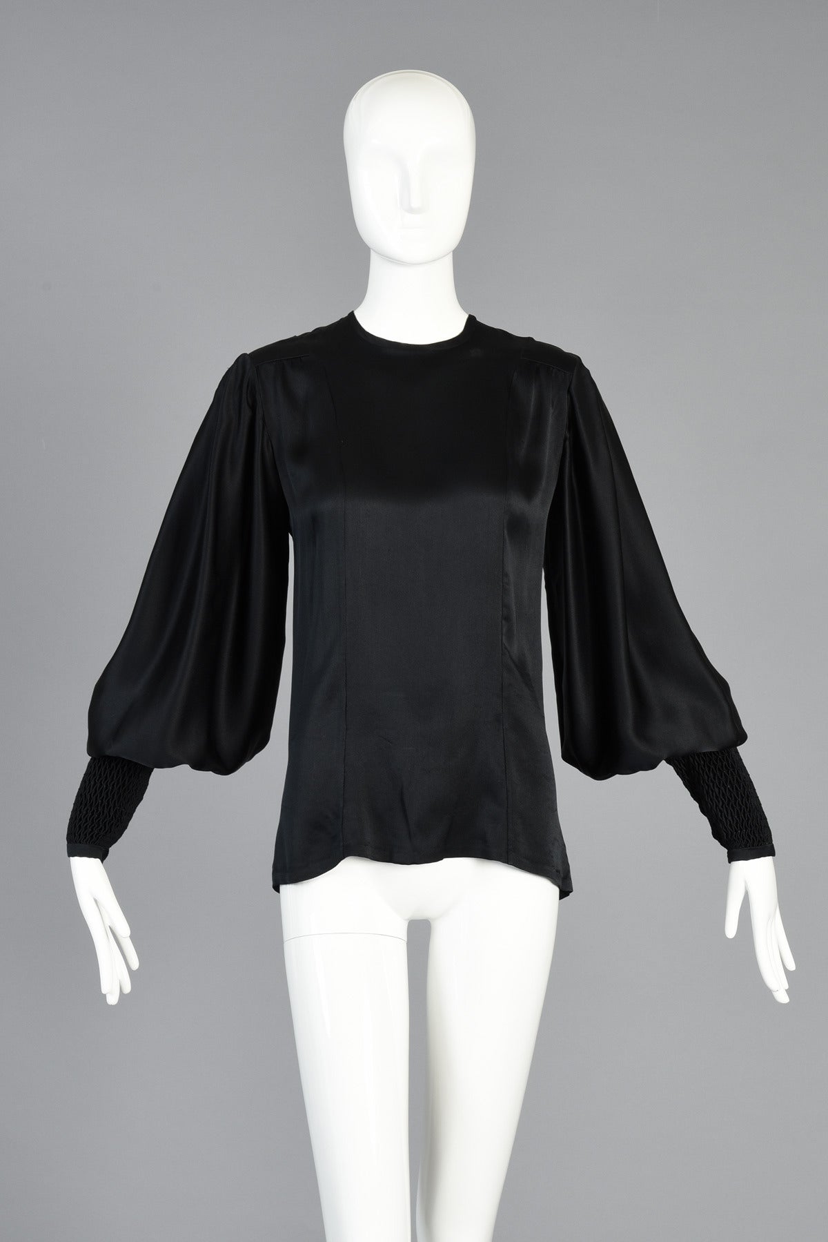 Stunning 1970s Thea Porter Couture black silk blouse with MASSIVE blouson sleeves. Soft fitted silk satin body with high neck and simple zipper down the back. Beautifully smocked cuffs reach from the wrist clear to the elbow with tiny hidden buttons