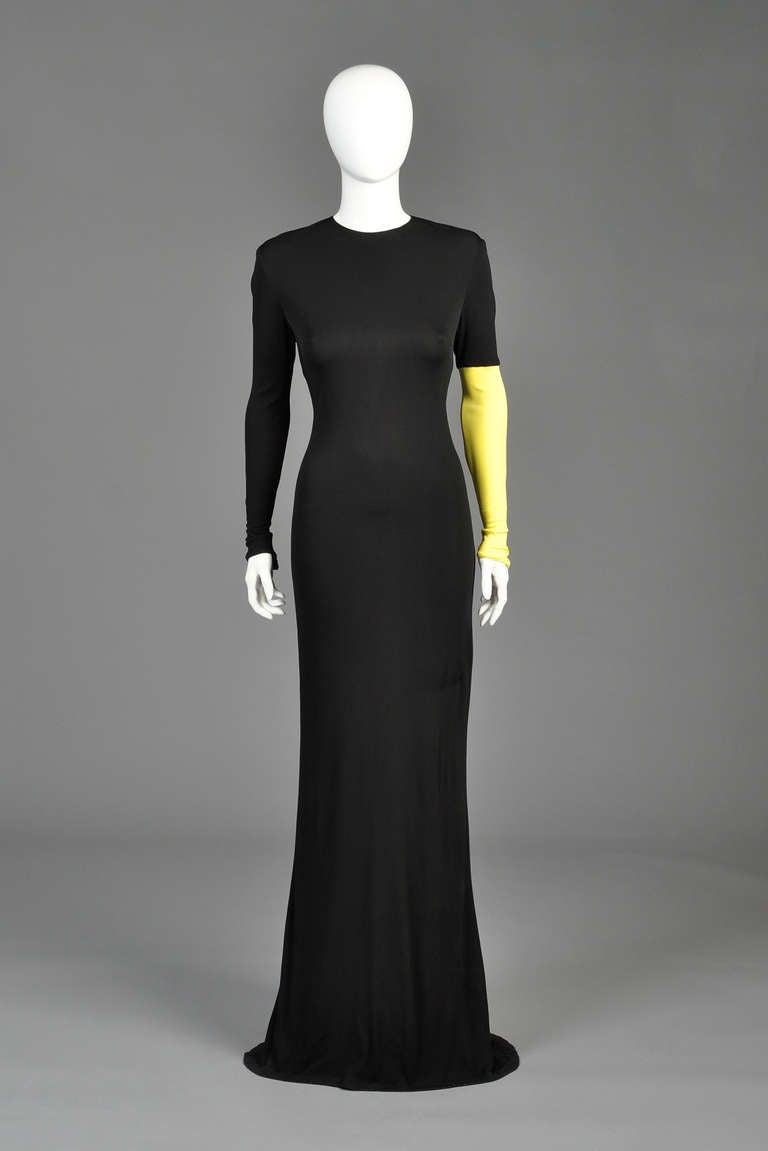 Just reduced from $1100 to $650

Superb 1990s Versace Couture evening gown. Ultra long, slinky black jersey with high neck and long sleek sleeves. We love the single yellow sleeve! Back zipper. 

MEASUREMENTS (un-stretched)
Bust: 32