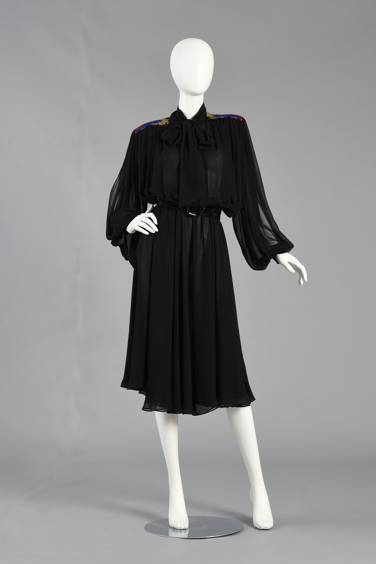 Bustown Modern is so happy to present this gorgeous 1980's black silk chiffon dress by Wayne Clark. Truly a stunning piece on with the most beautiful construction. Layered chiffon skirt with elastic waist, jeweled button up front and attached long