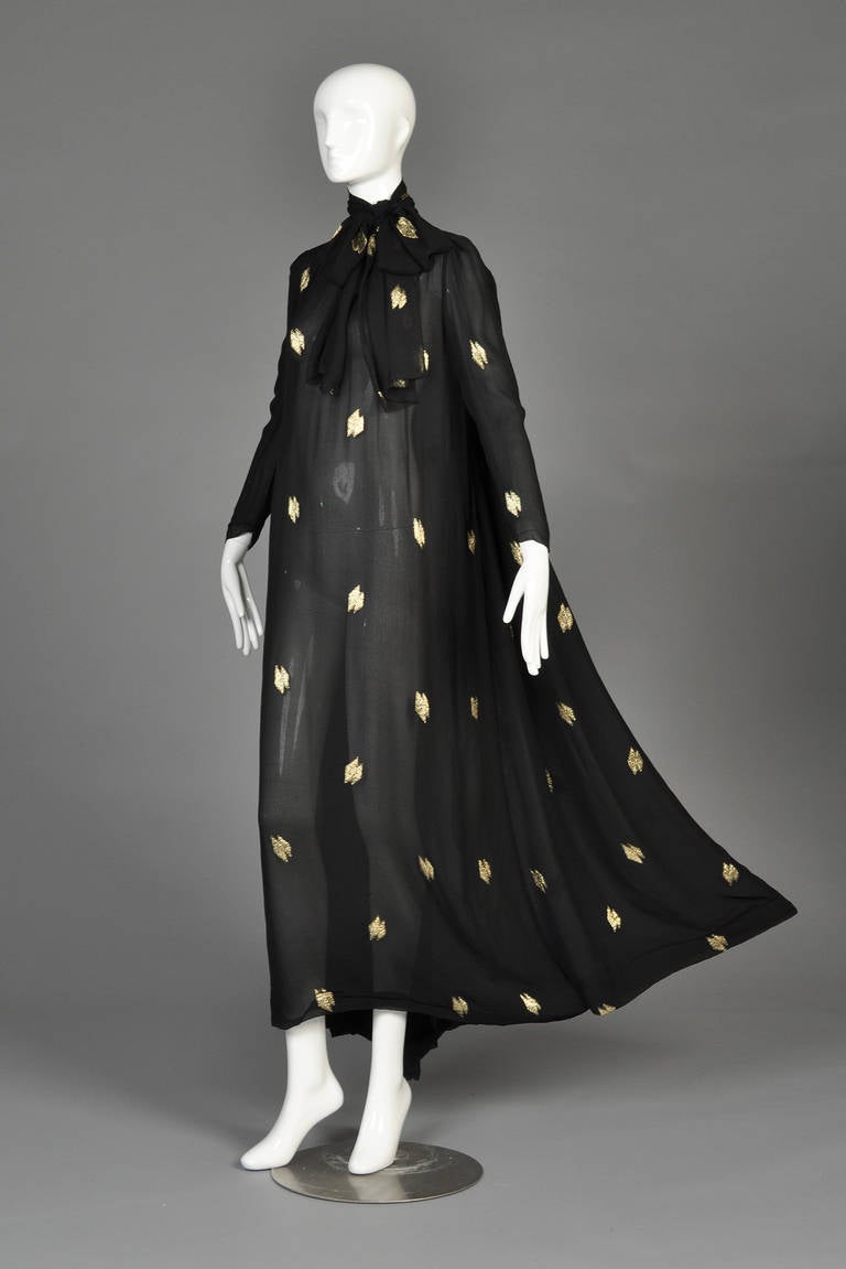ABSOLUTELY incredible 1970s black sheer silk gown with metallic gold lurex running throughout. Marc Bohan for Dior. Ultra long length with long sleeves, single button closure and attached scarf. AMAZING draped panels in back hang like curtains while