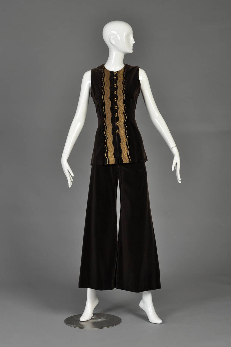 Absolutely stunning 1970s Thea Porter velvet pantsuit. Dark chocolate brown rayon velvet with high-waisted zip-front bell bottom trousers + sleeveless tunic top. The top features spectacular copper colors lace with round copper buttons + gold