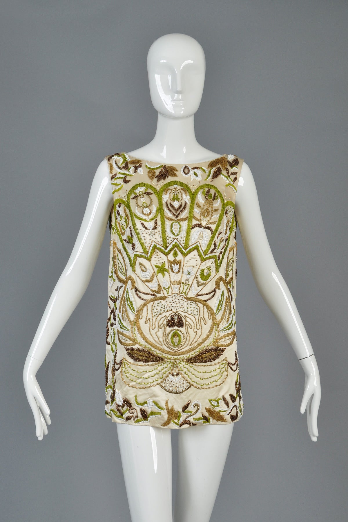 Truly incredible 1960s hand beaded silk tunic. Spectacular, rare find. A once in a lifetime find! Pale vanilla colored silk satin is fully hand-beaded with scalloped fanned and lotus flower motif. Metal zipper in the back. 

MEASUREMENTS
Bust: