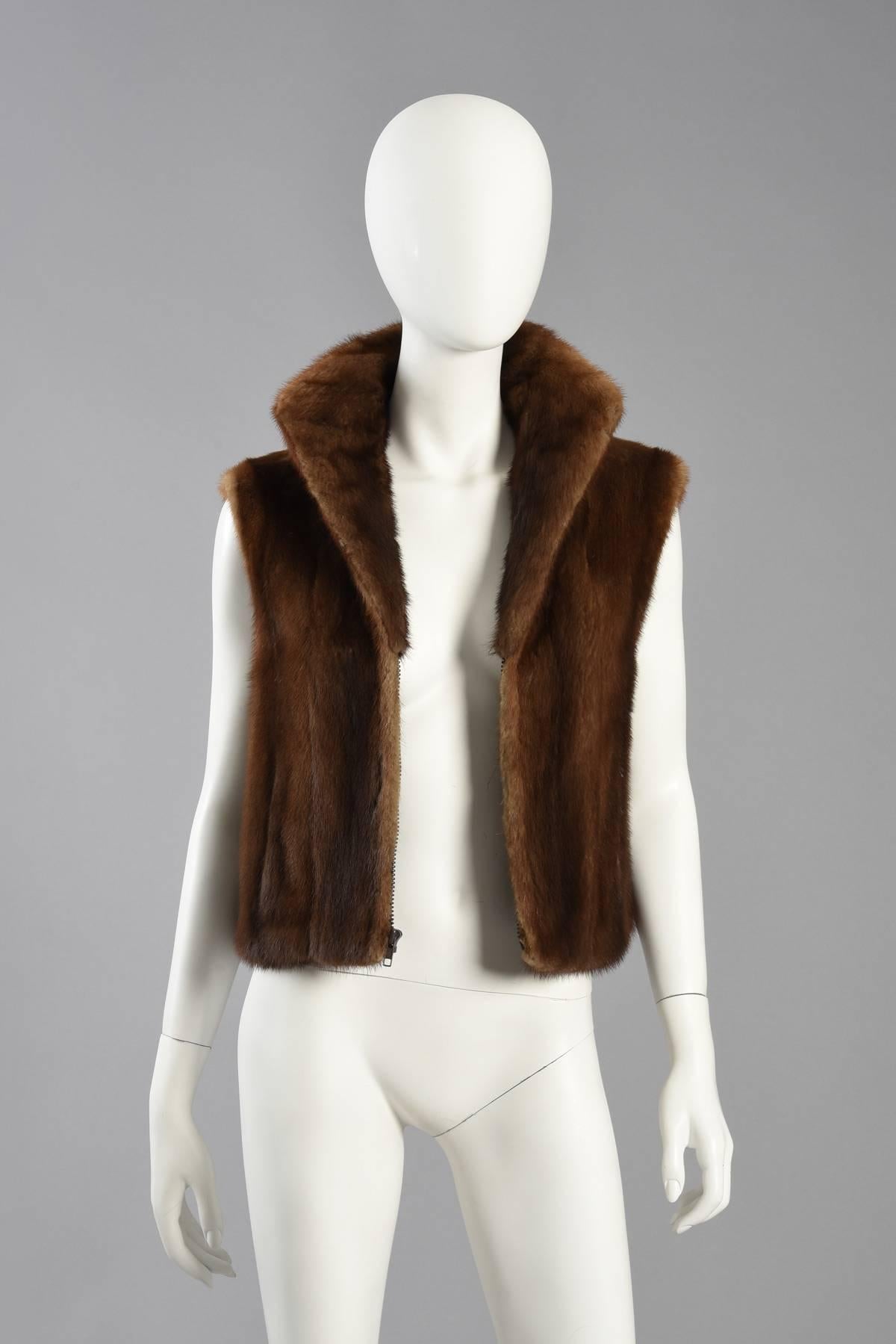 Killer Neiman Marcus genuine mink fur vest. Simple and chic, this piece is just as easy to style overtop of leather jackets and sweaters as it is to wear it on its own. Simple zip front with fur-backed collar that can be worn standing. Ultra wide,