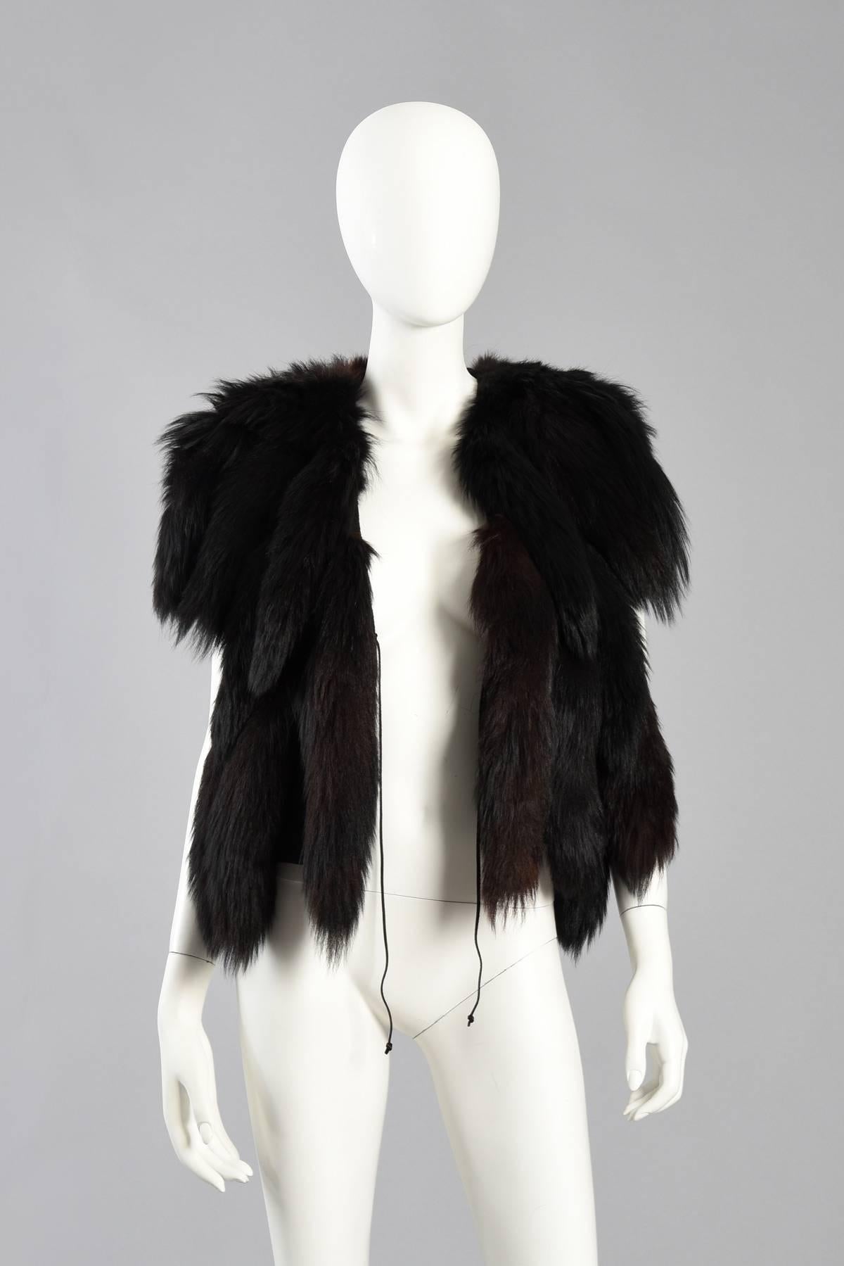 Excellent fox tail fringed gilet. We've had several similar vests in the past but have never been lucky enough to find one in all black!

Cropped length with black wool body and genuine fox tail 