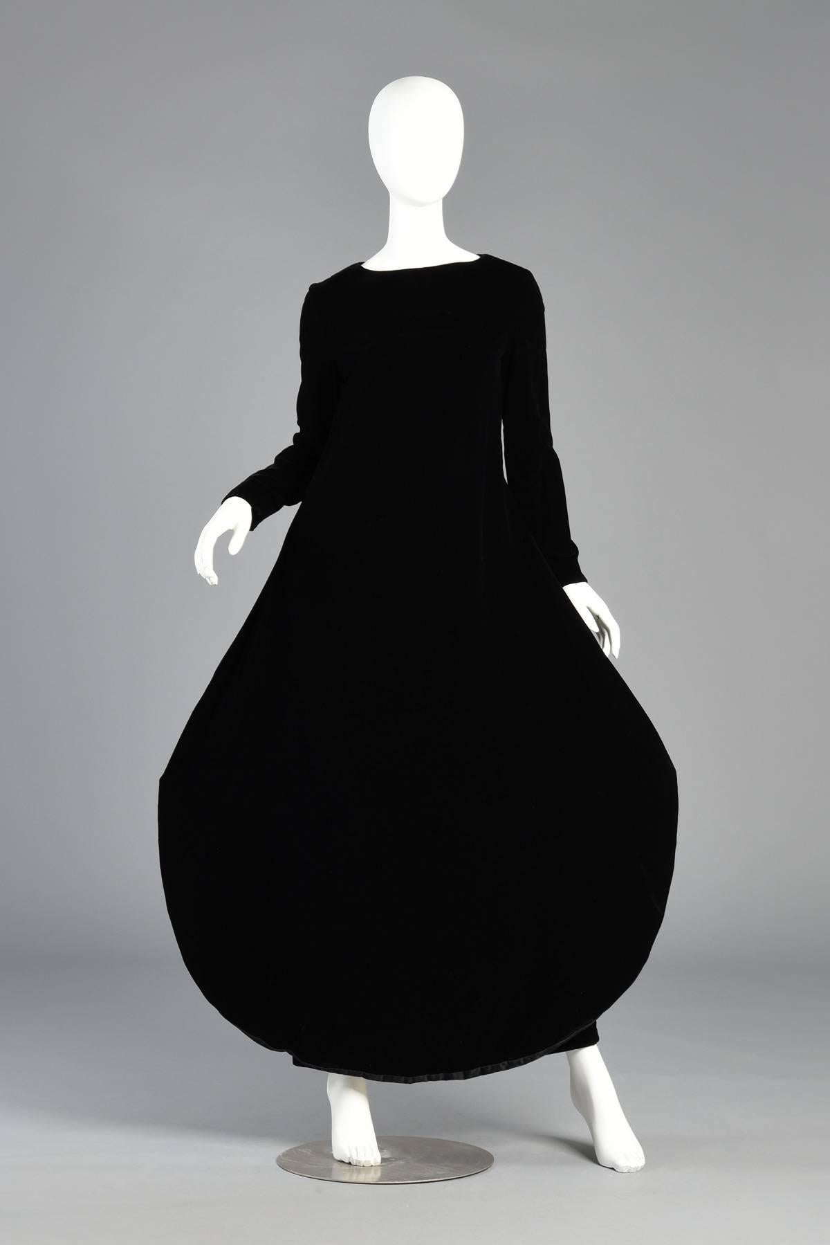 Iconic vintage apron paneled velvet maxi gown by Pierre Cardin, circa 1969-1971. Simple and demure black longsleeve velvet gown. Massive rounded “apron” panel creates a striking silhouette. Excellent vintage condition. Classic Cardin. Magazine photo