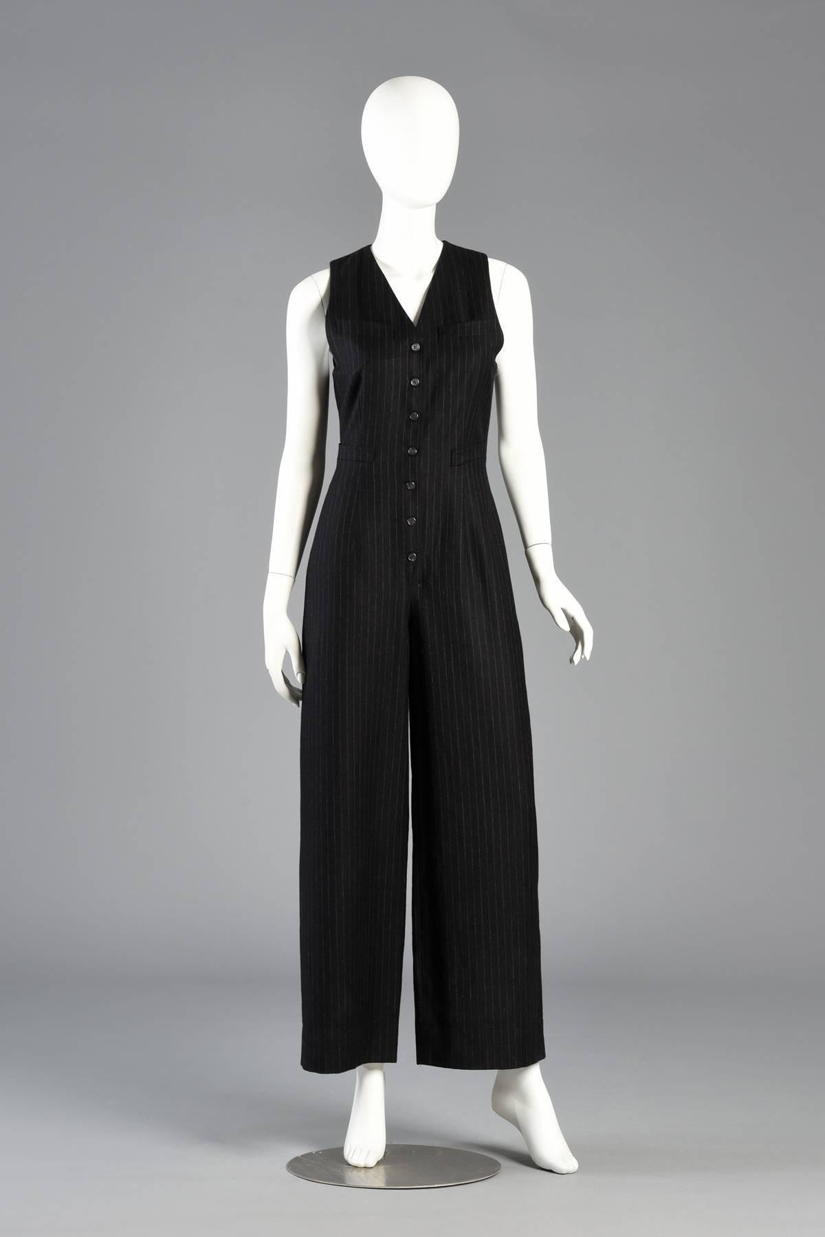 Chic 1990s menswear style at it’s best in this vintage Ralph Lauren pinstripe wool one-piece jumpsuit. Dark black/charcoal wool jumpsuit with lighter gray pinstriping. Menswear suit vest style bodice — even has tiny vest pockets and buckle cinch