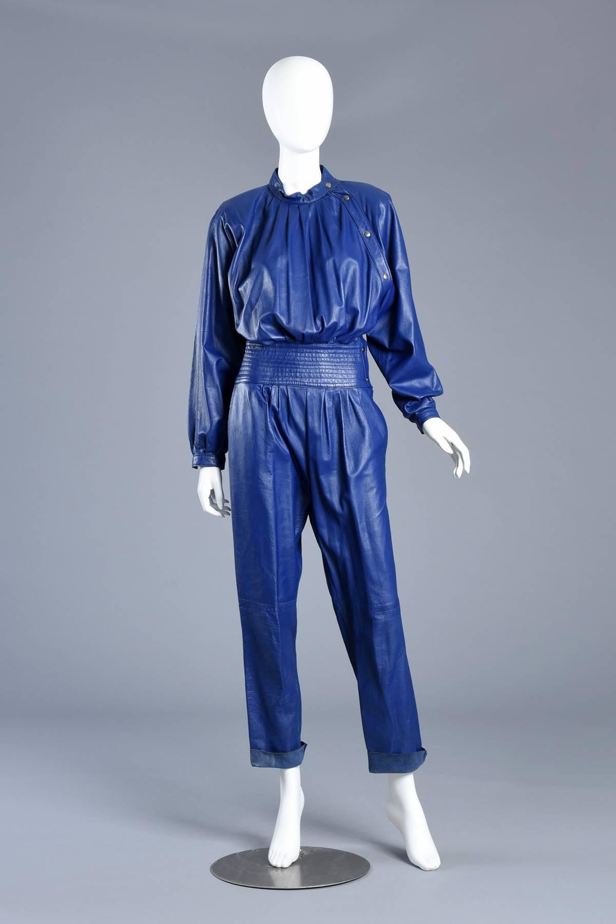 Super great 1980s leather jumpsuit in a rare indigo color. It's so hard to find leather jumpsuits and when we do they are more often than not a classic black. 

This piece features a high gathered neck and bust with asymmetric snap closures,