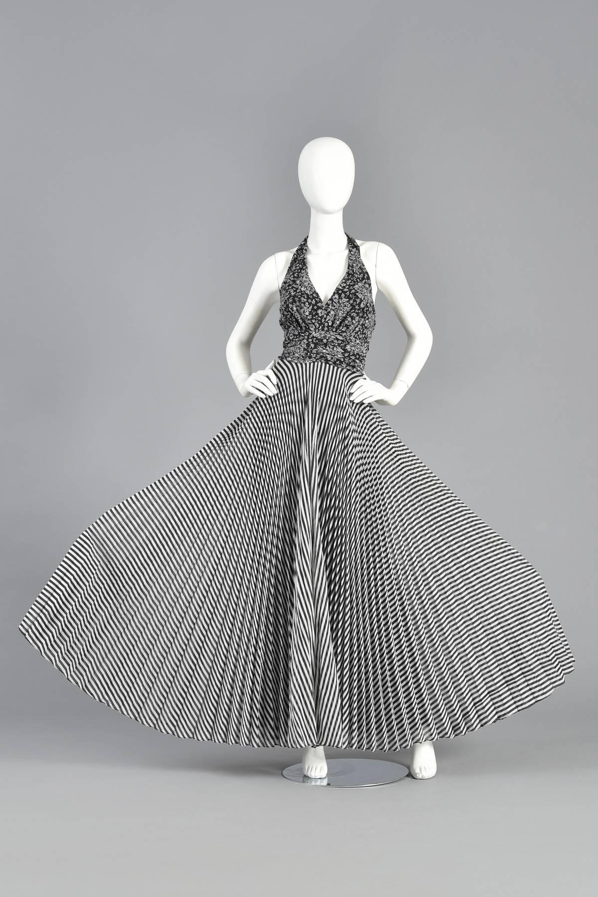 Absolutely awesome 1970s gauze maxi dress. Incredible black and white op-art pleated & striped full skirt with contrasting floral bodice. The backless halter bodice features a plunging neck and fitted midriff. Made from semi sheer cotton/poly blend