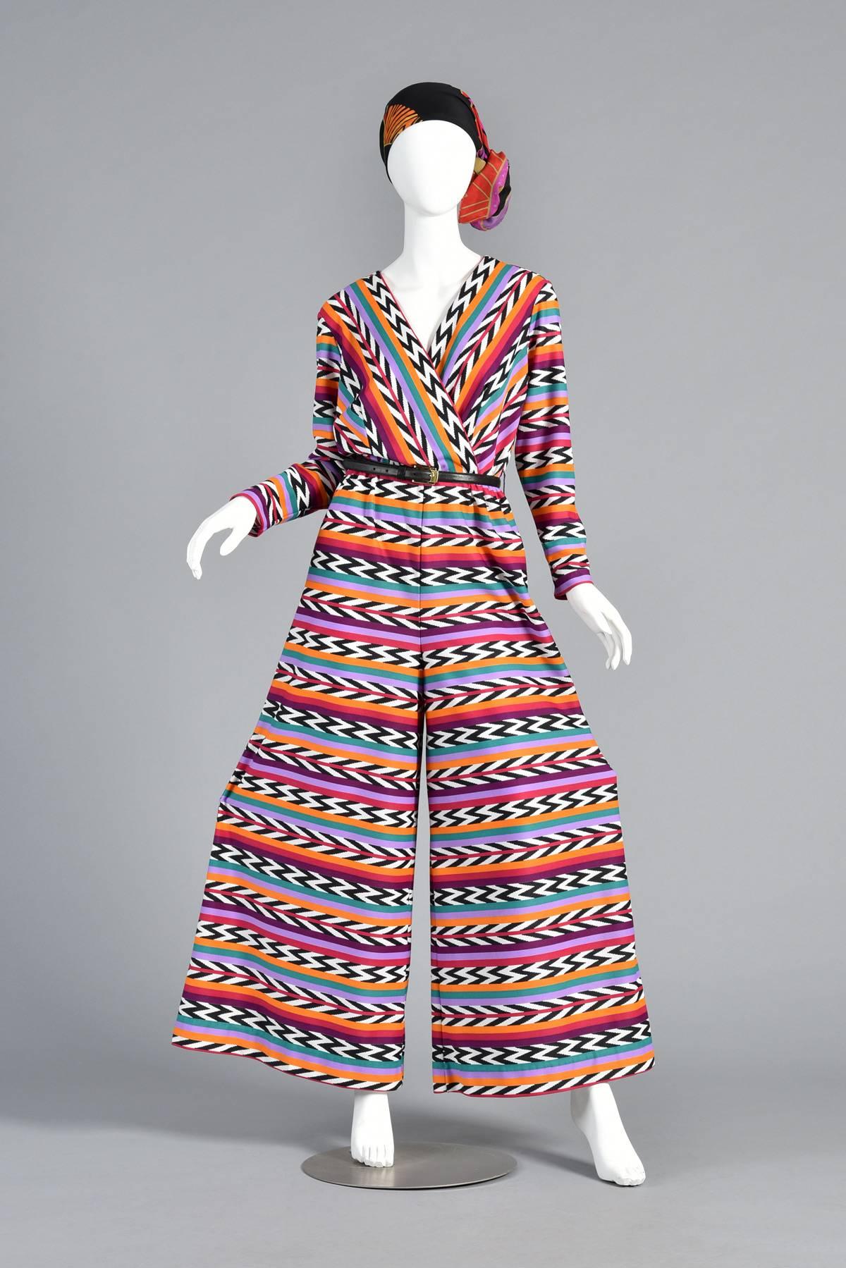 Incredible vintage 1970s graphic striped palazzo jumpsuit. Alternating rainbow stripes and b/w zig zags and chevrons in a bright Southwestern color palette. Plunging criss cross bodice. Super wide palazzo legs. Excellent vintage