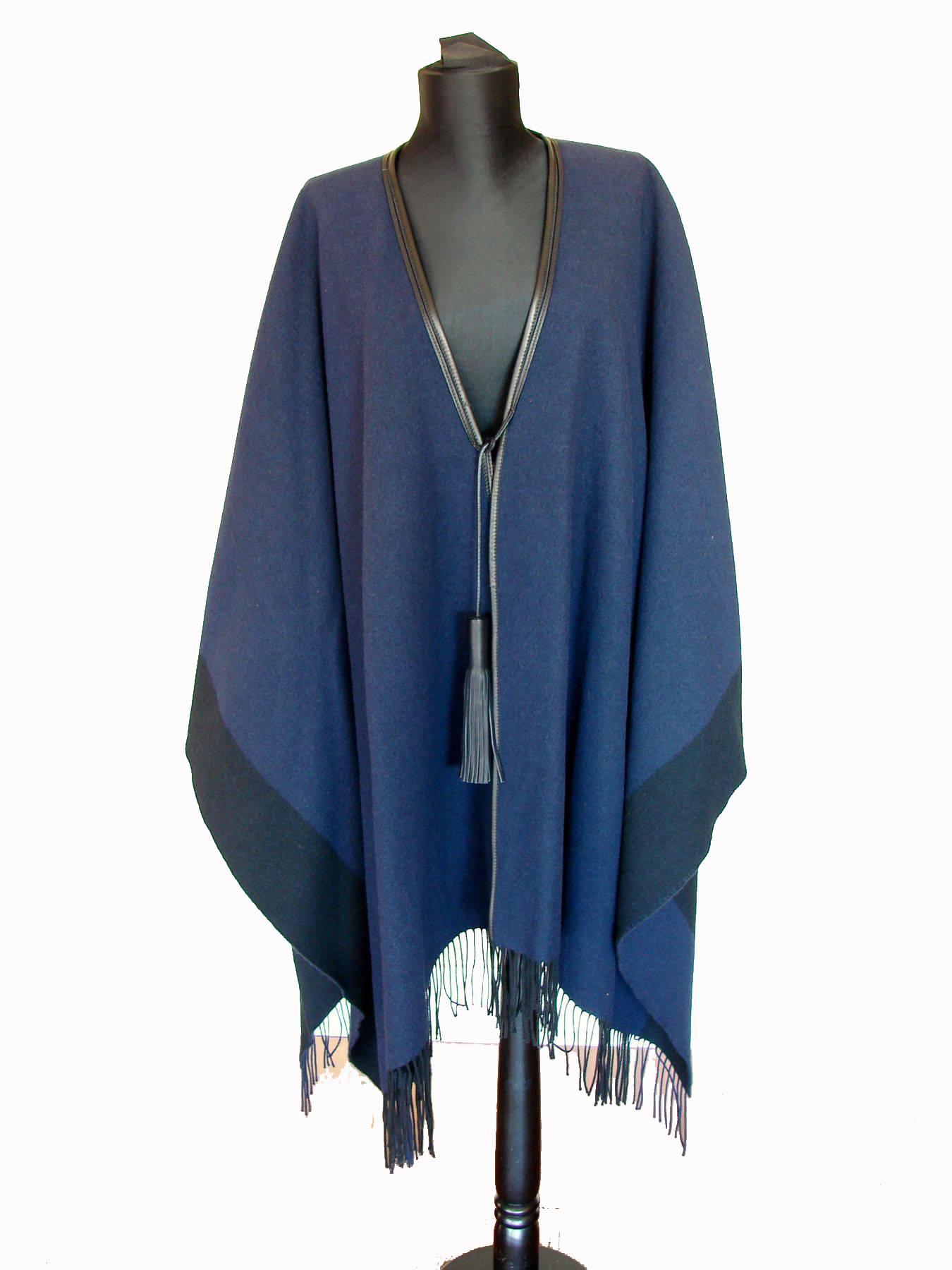 Wool & cashmere blend color block poncho or cape from HERMES is trimmed in black leather and features two leather tassels.  Hem features wool & cashmere fringe. One Size Fits Most, it measures appx 62