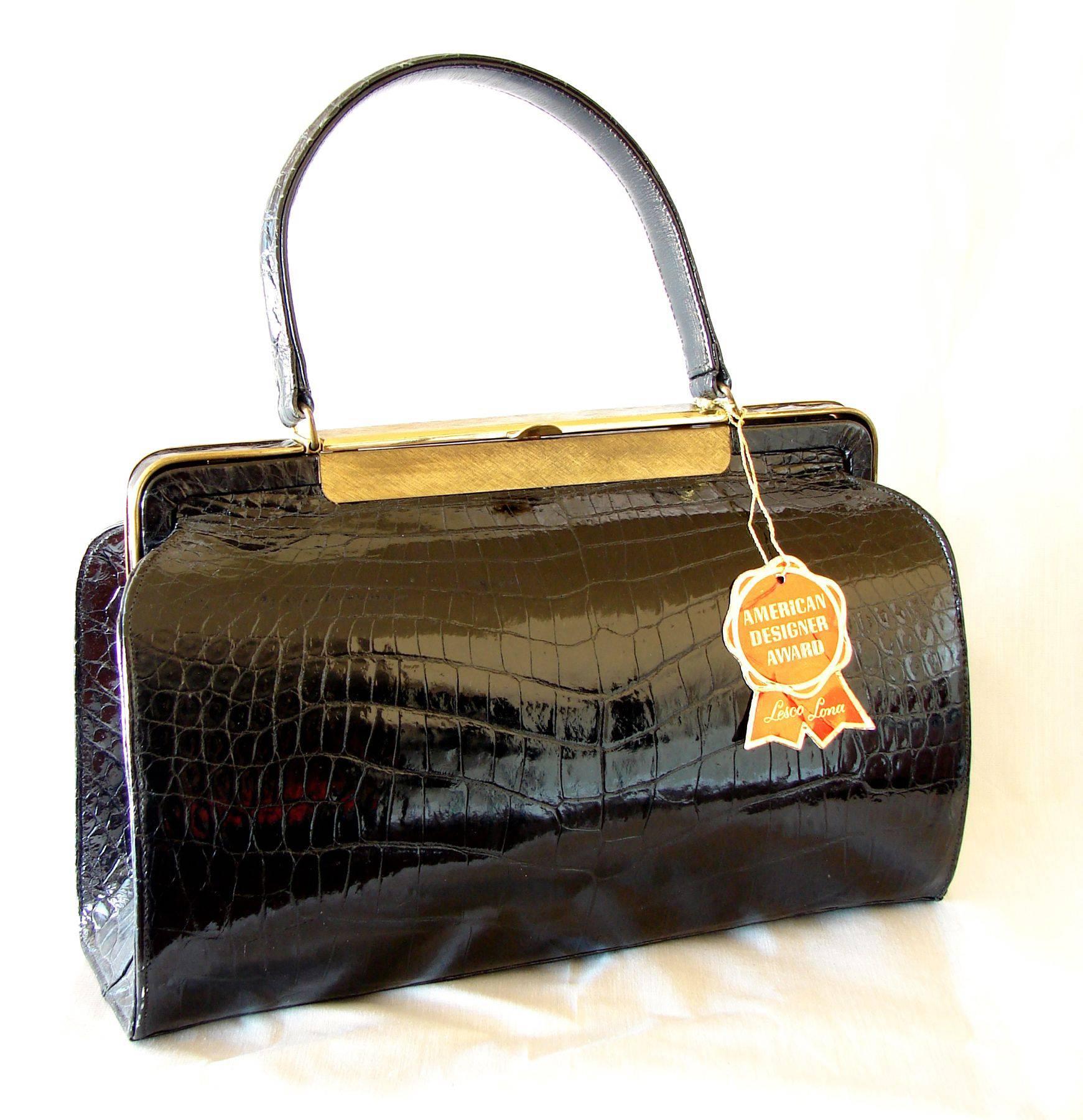 Fancy black exotic crocodile handbag from Lesco Lona dates to the early 1960s.  Known for their exotic skin bags, this piece is a great example of their quality craftsmanship.  The exterior is black shiny crocodile with gold hardware, and inside