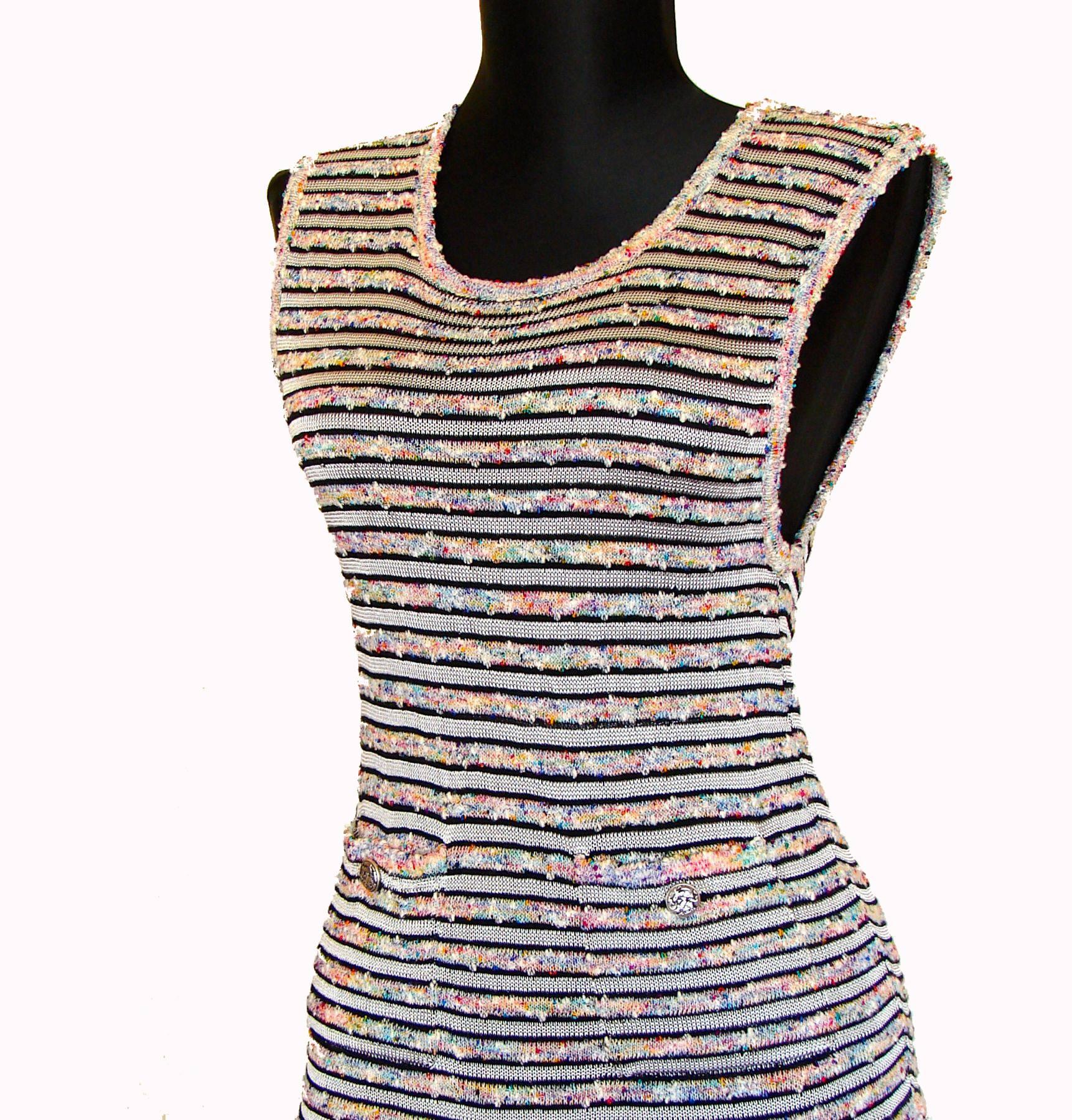 This fabulous dress is from Chanel's 2011 collection.  Made from a gorgeous knit in ecru, it features black stripes and alternating strips of rainbow boucle wool.  It has two pockets in front with silver CC logo buttons and a dropped waist.  Looks