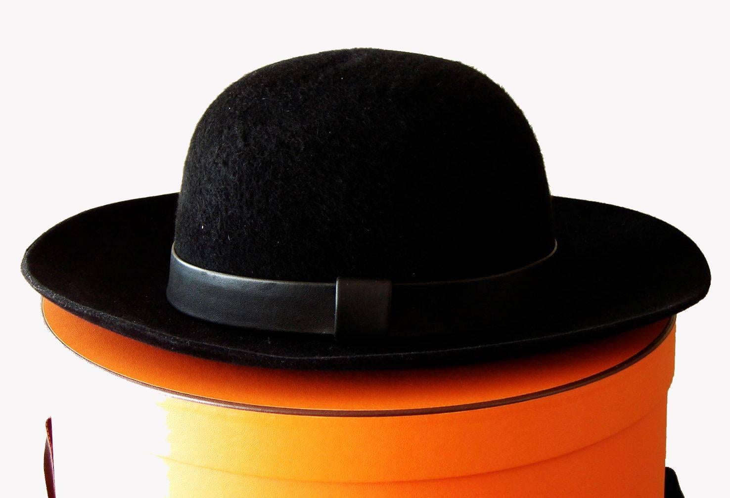 Here's a rare and downright GORGEOUS wide brim hat from HERMES!!
Made from supple black rabbit felt in a plush finish, it features a black leather band around the crown! Comes with its original tag, and in it's oval hat box with ribbon for safe