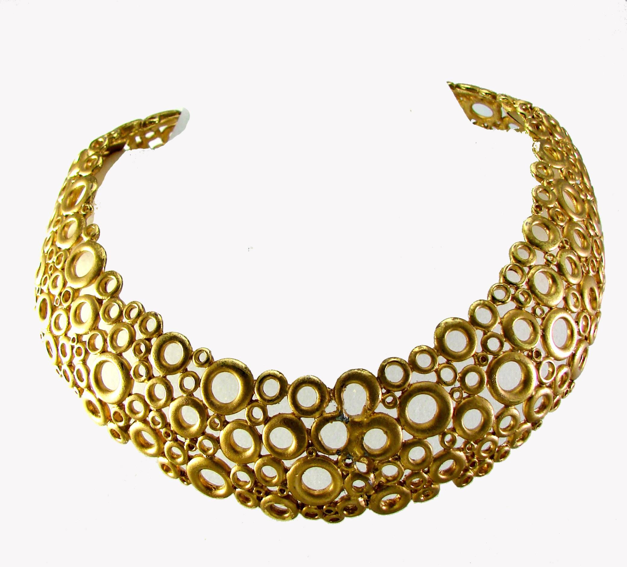 This collar necklace was made by GIVENCHY c1970s and is made
from gilt metal fashioned into a modernist batch of circles! Very cool piece! Features two hinges to set the piece around your neck. In very good condition for its age, upon close