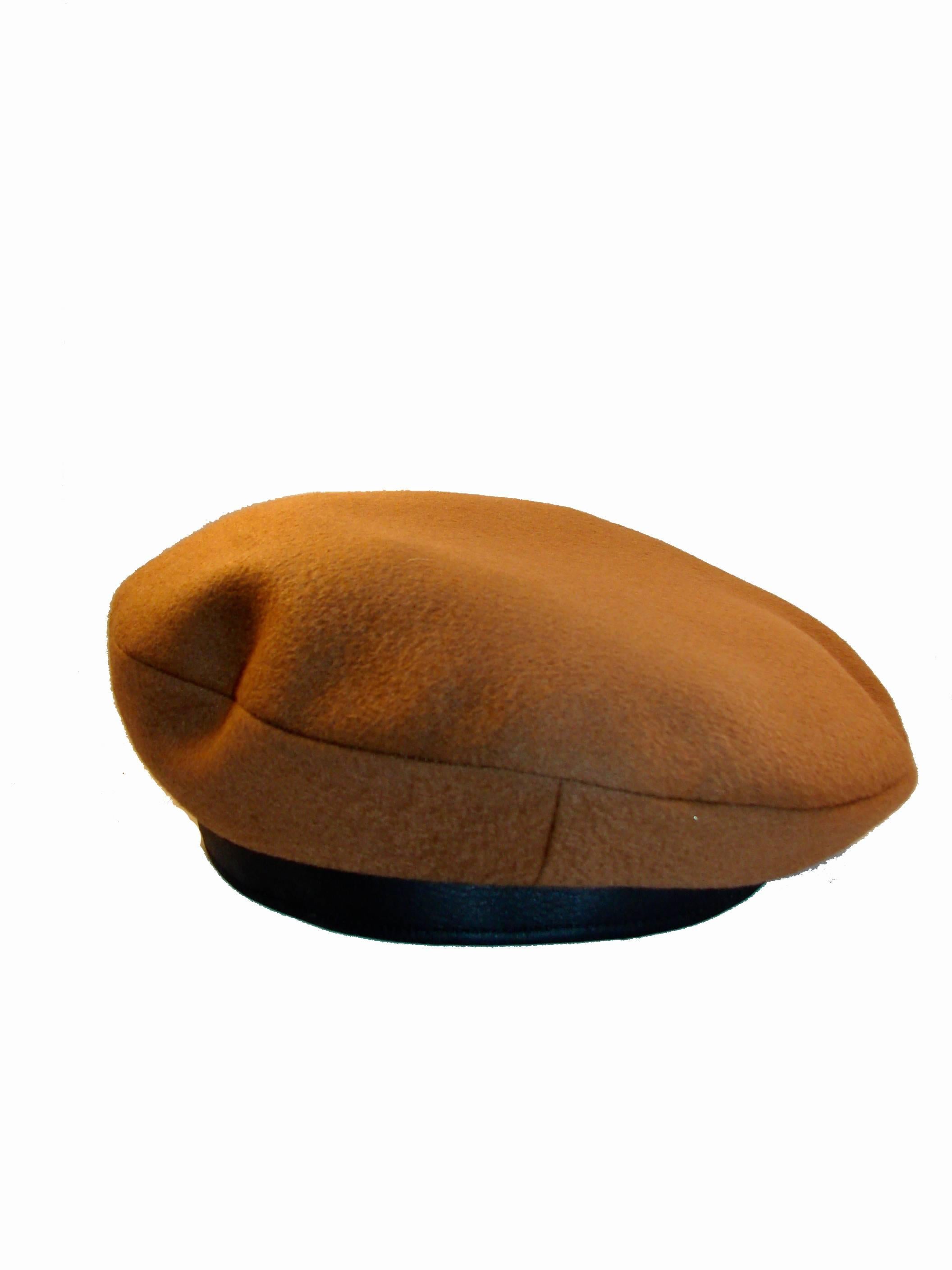 Here's a gorgeous camel-colored cashmere and dark brown leather beret from Hermes.  Fully-lined. In very good preowned condition with some minor scratching to the leather trim (hard to see unless closely inspecting).  Tagged HERMES and SIZE 59, it
