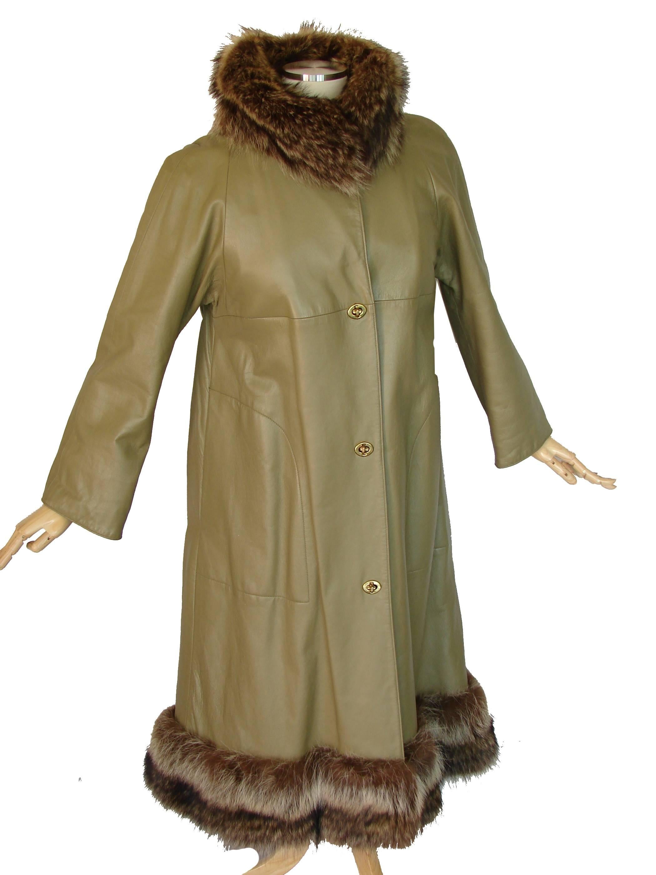 This fabulous coat was designed by the mother of American sportswear, Bonnie Cashin in the 1960s.  Made from a light olive colored Angola leather, it features raccoon fur trim at the collar and hem.  Lined in faux fur fabric.  Fastens with Bonnie's