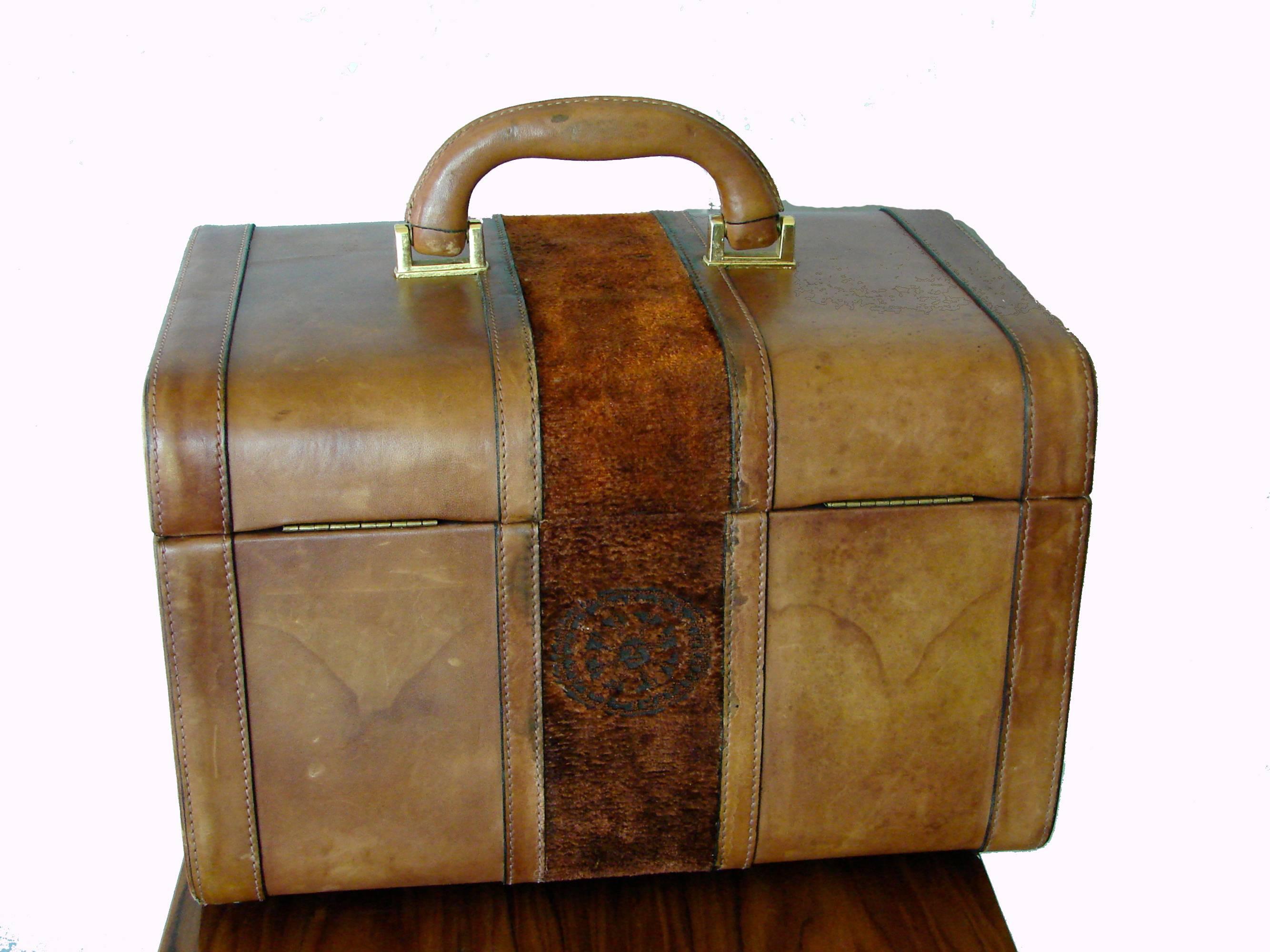 A rare toiletry or train case designed by Giuliana Camerino in the late 1970s.  Made from saddle leather, it features an amber brown colored Soprarizzo velvet center embossed with the Roberta di Camerino insignia.  The interior is lined in black