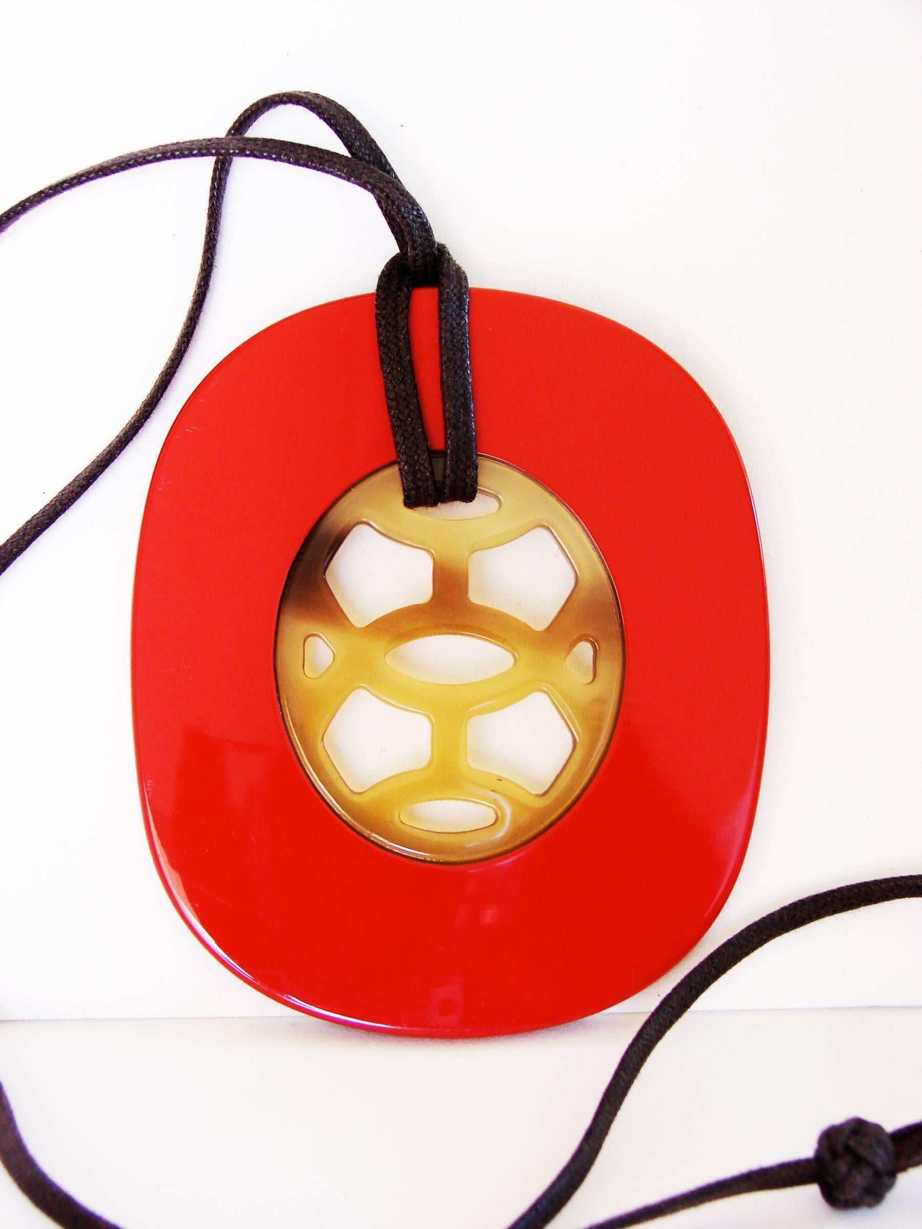 Incredibly stunning pendant with adjustable necklace from Hermes Paris.  Made from Buffalo Horn and Carmine red lacquer, it comes in its original box with felt cover and paperwork.  In excellent condition with very minor scratching, hard to see