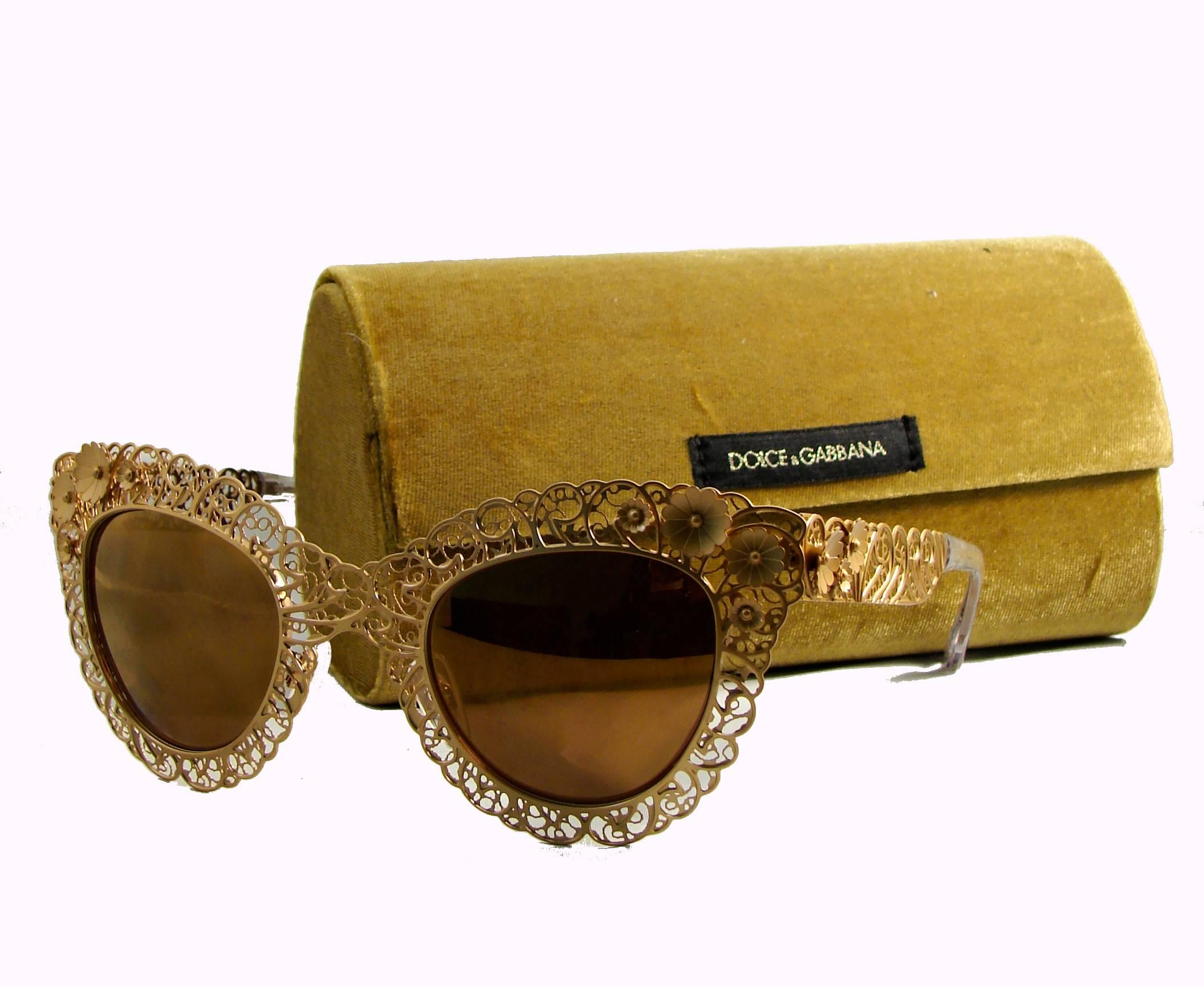 These sunglasses are so pretty! Made from a gold metal frame, with scrolling metalwork and dimensional floral blooms surrounding the cat-eye lenses.  In excellent condition.  Come with their paperwork and gold velvet eye glass case.