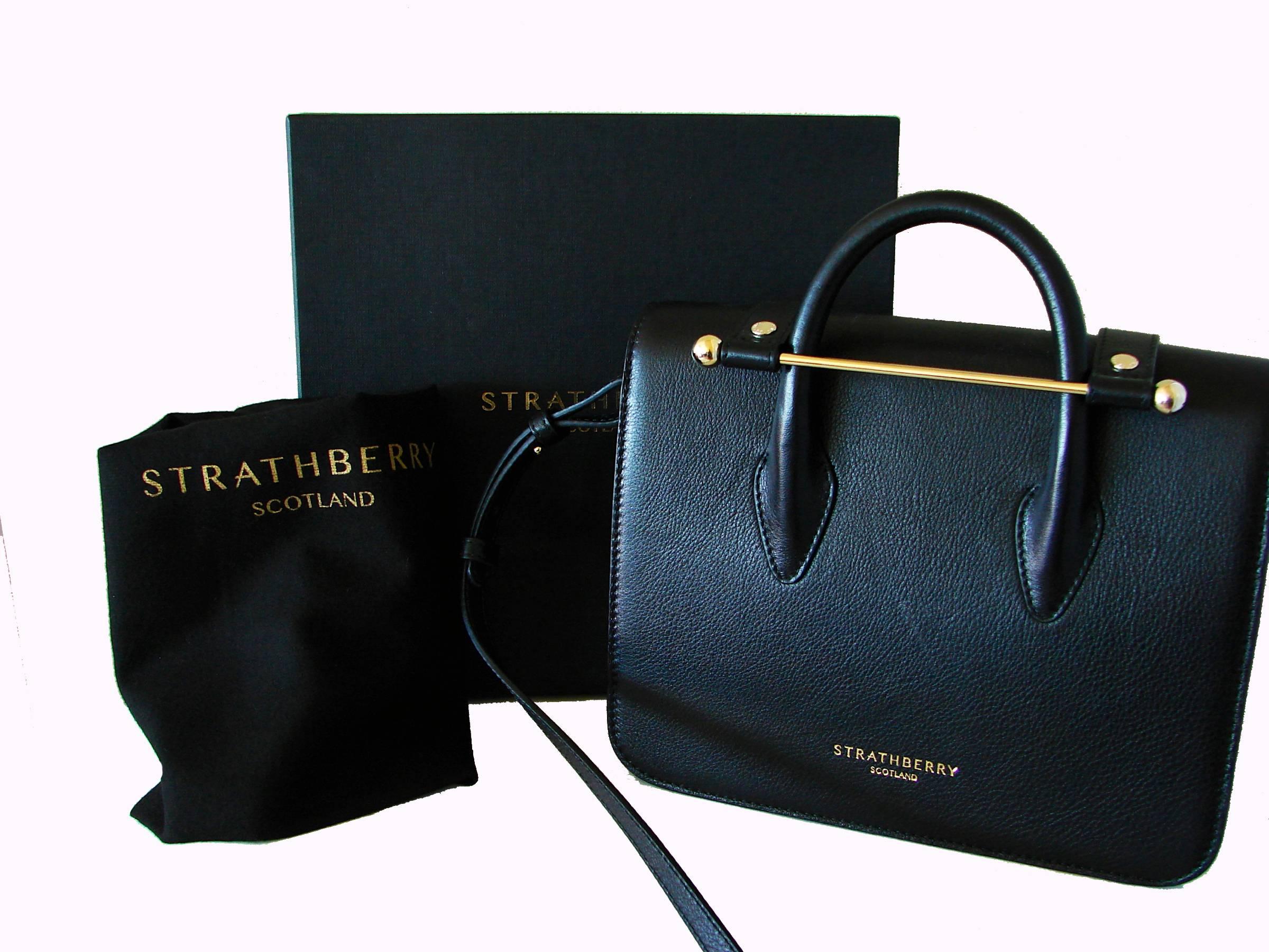 Classy bag from Strathberry Scotland.  Made from black leather, it features a unique gold bar closure - so chic! Easy to wear as top handle or with adjustable shoulder strap.  Brand new in box, comes with dust cover, too.  Measures 7.5
