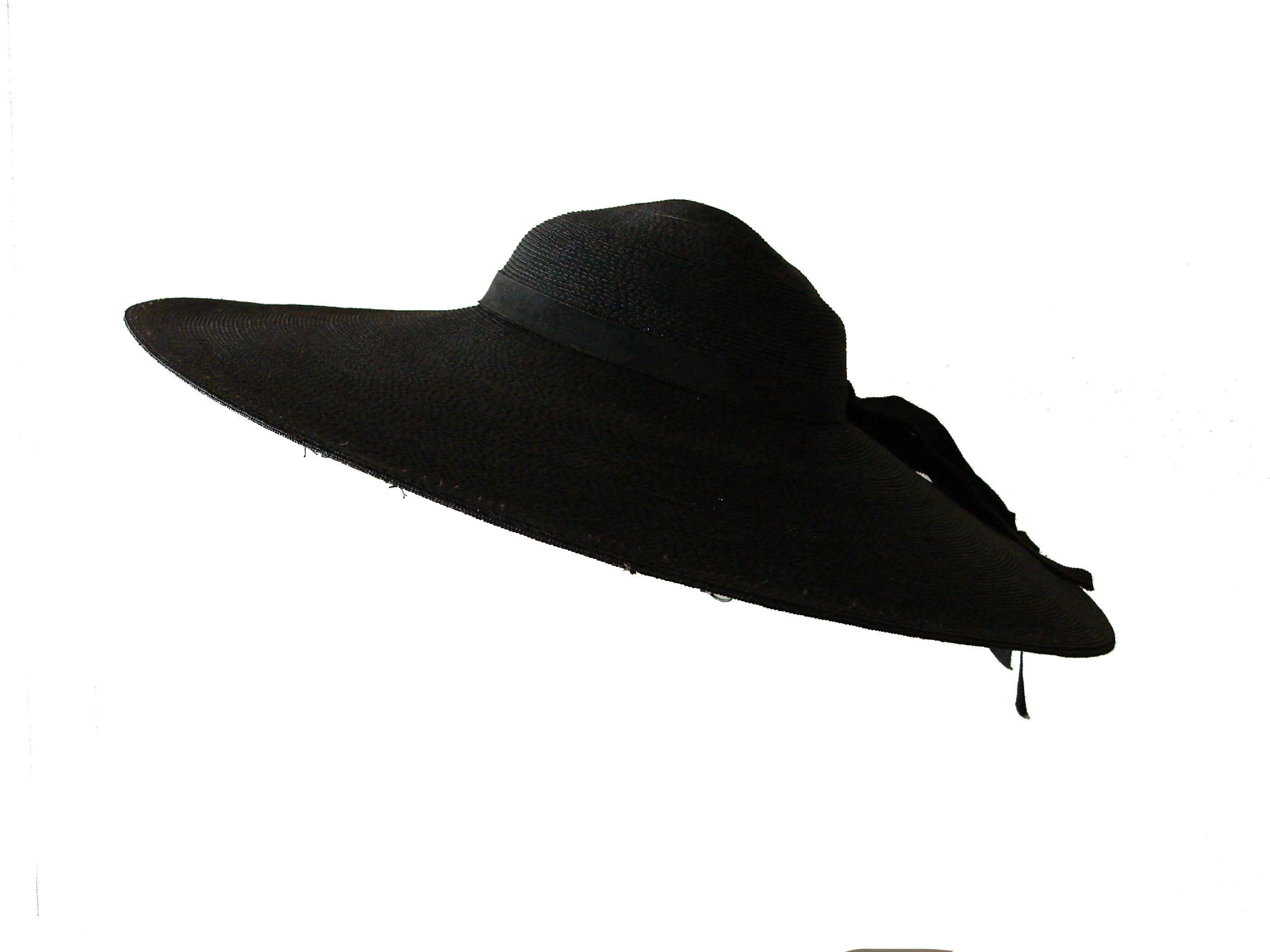 This stylish hat is estimated to be from the 1940s and is made from a flexible black straw weave.  It features a ribbon around the crown which dangles from the back.  No size or manufacturer label, but it measures 19