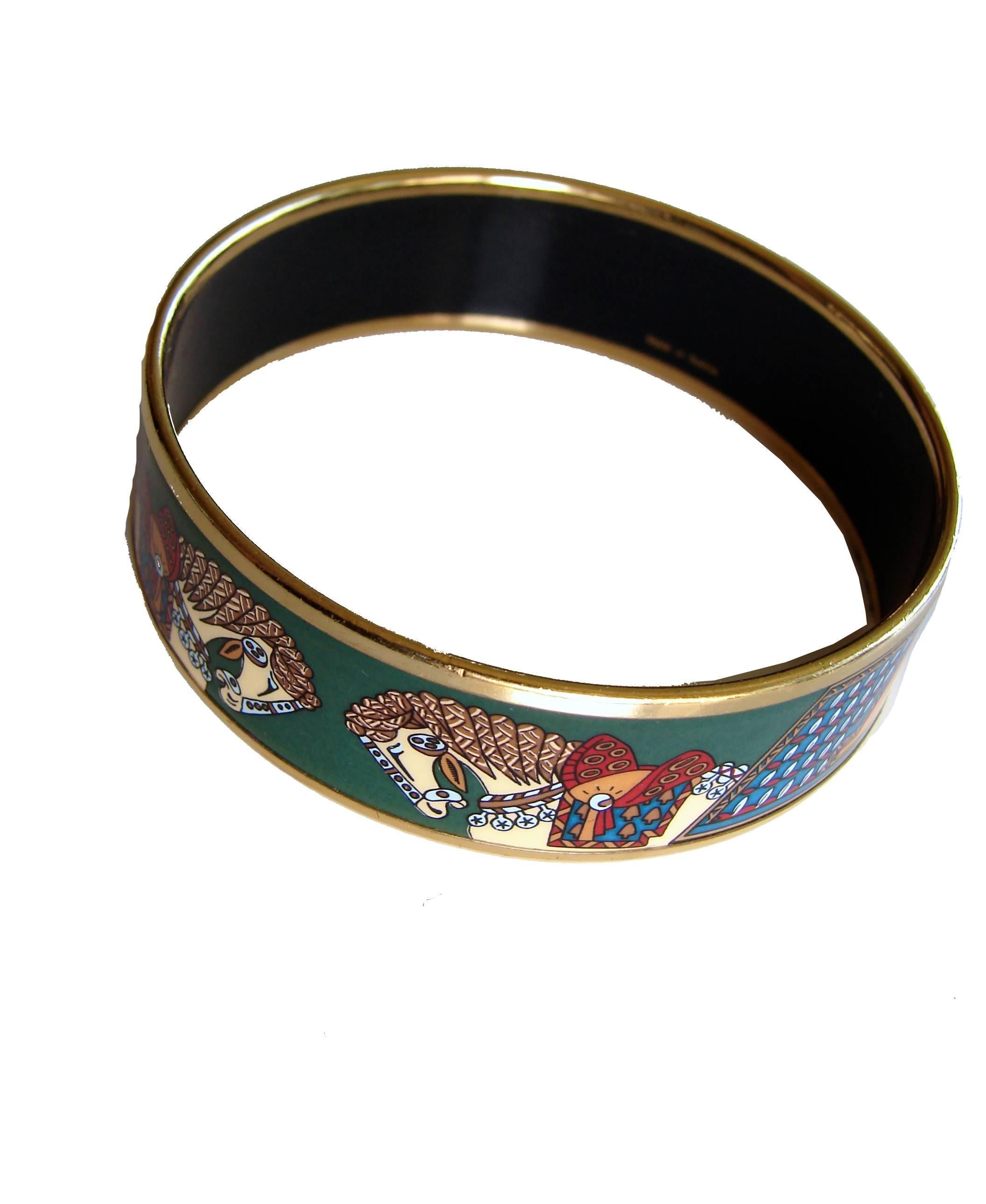 Vintage bracelet designed by Hermes in the 1990s.  Features an equestrian theme in shades of green, orange and white with gold edges.  In good condition for its age, we note several dings to the enamel from wear and scratching to the gold edges. 