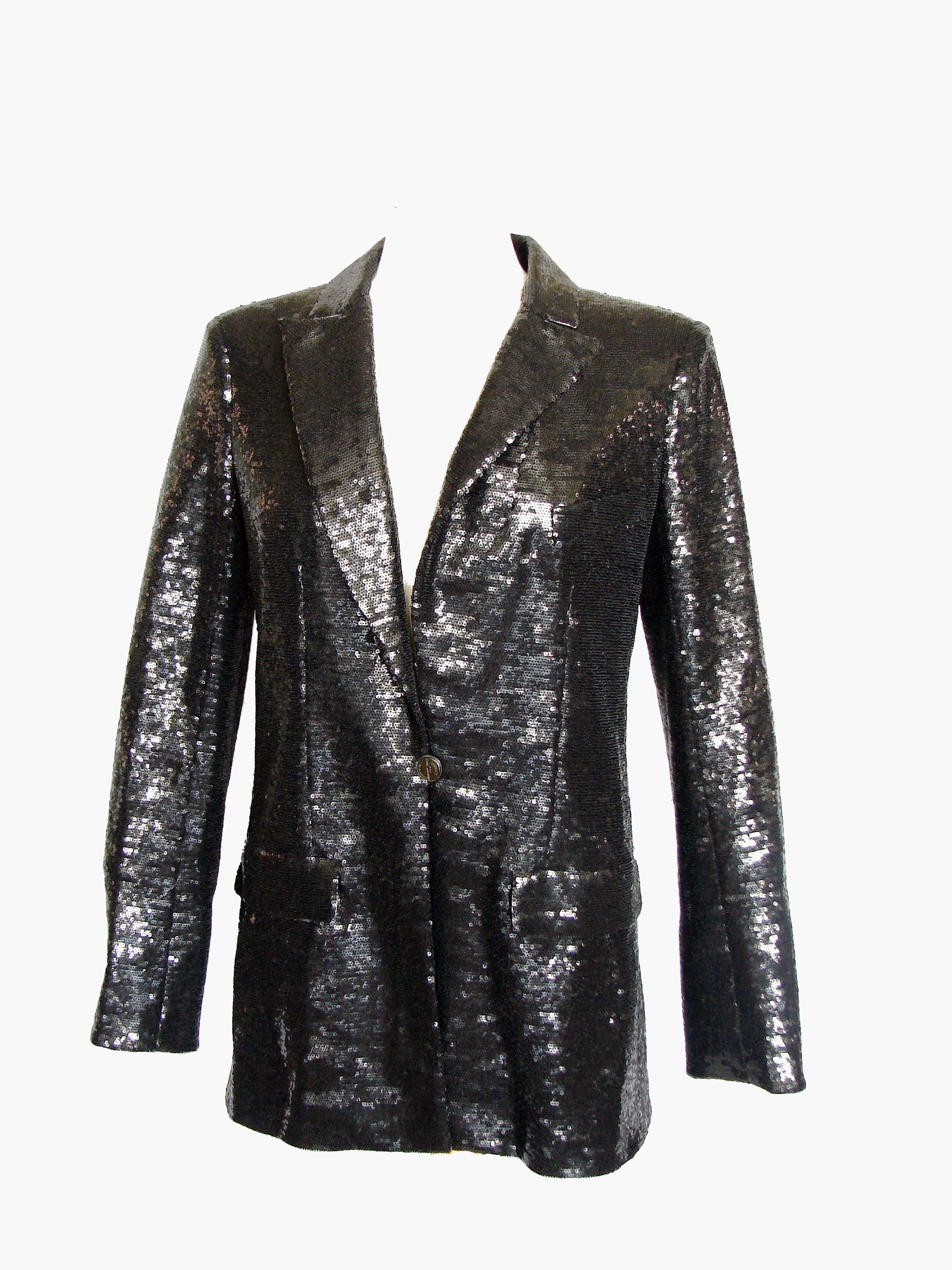 This 09C collection jacket features tons of shimmering black sequins and fastens with a single Chanel CC button.  The sleeve bottoms can be rolled up to expose a white silk satin cuff (see image 6) and there's white silk satin under the collar as