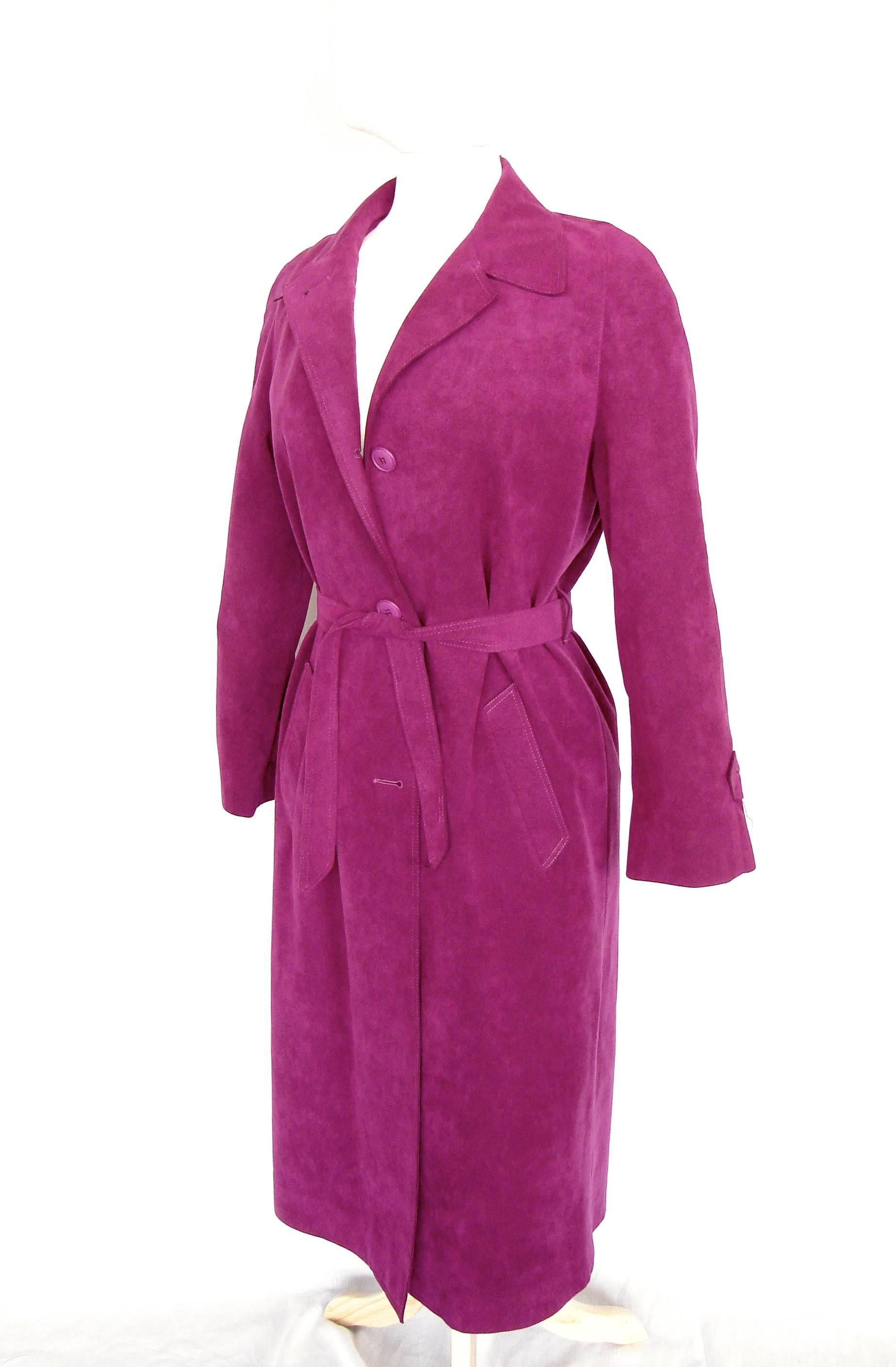 This Lilli Ann coat was made in the late 1970s and is made from an eye-popping magenta Ultrasuede fabric! Fully-lined, it comes with its original belt.  In excellent condition overall, we note four missing buttons: one on the back of each sleeve