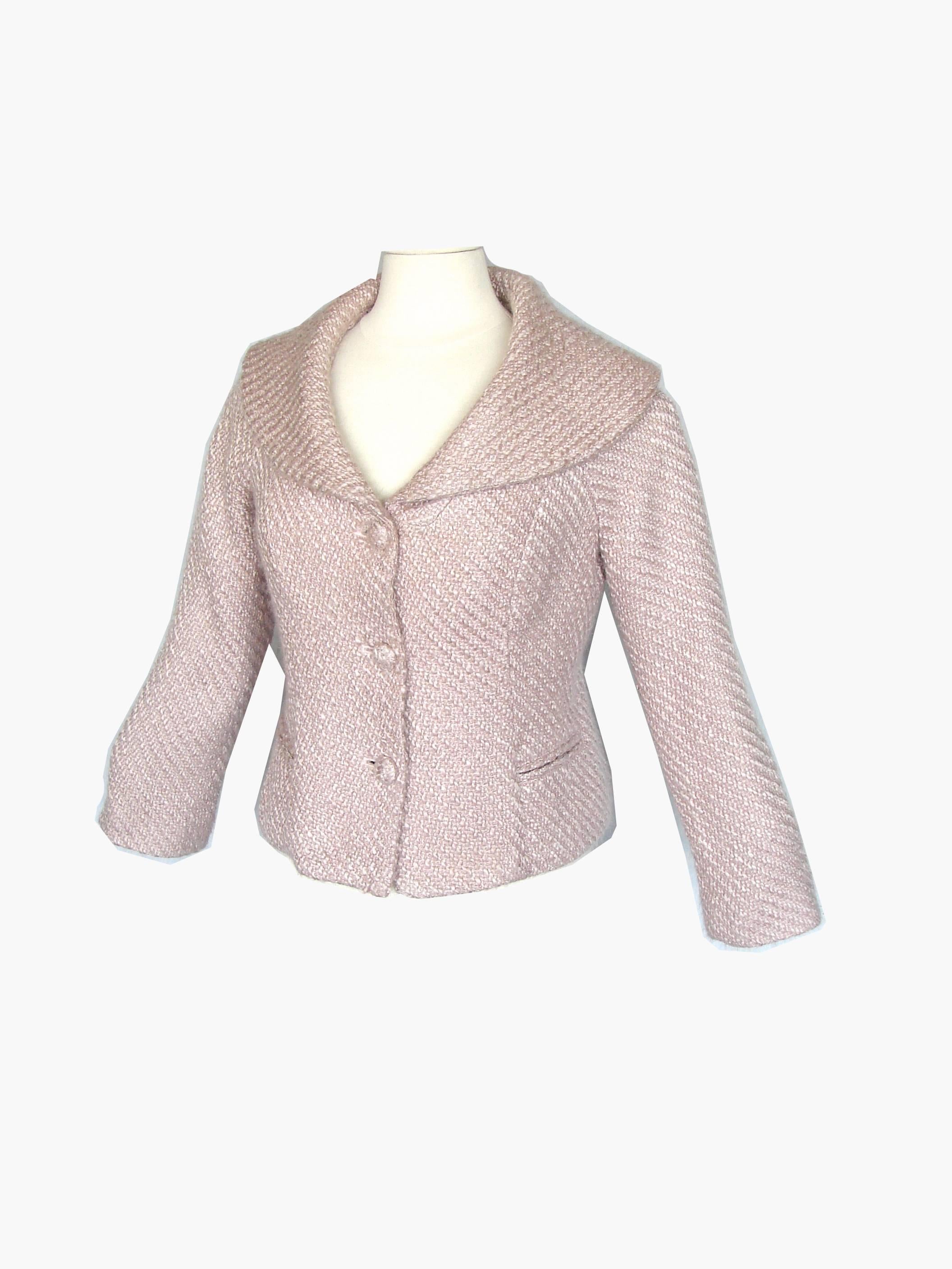 This little knit jacket was made by Pierre Cardin in the 1980s.  Made from a supple pale pink and white knit, it features a shawl collar and fastens with three knit covered buttons.  Fully-lined in white Pierre Cardin logo fabric.  In excellent