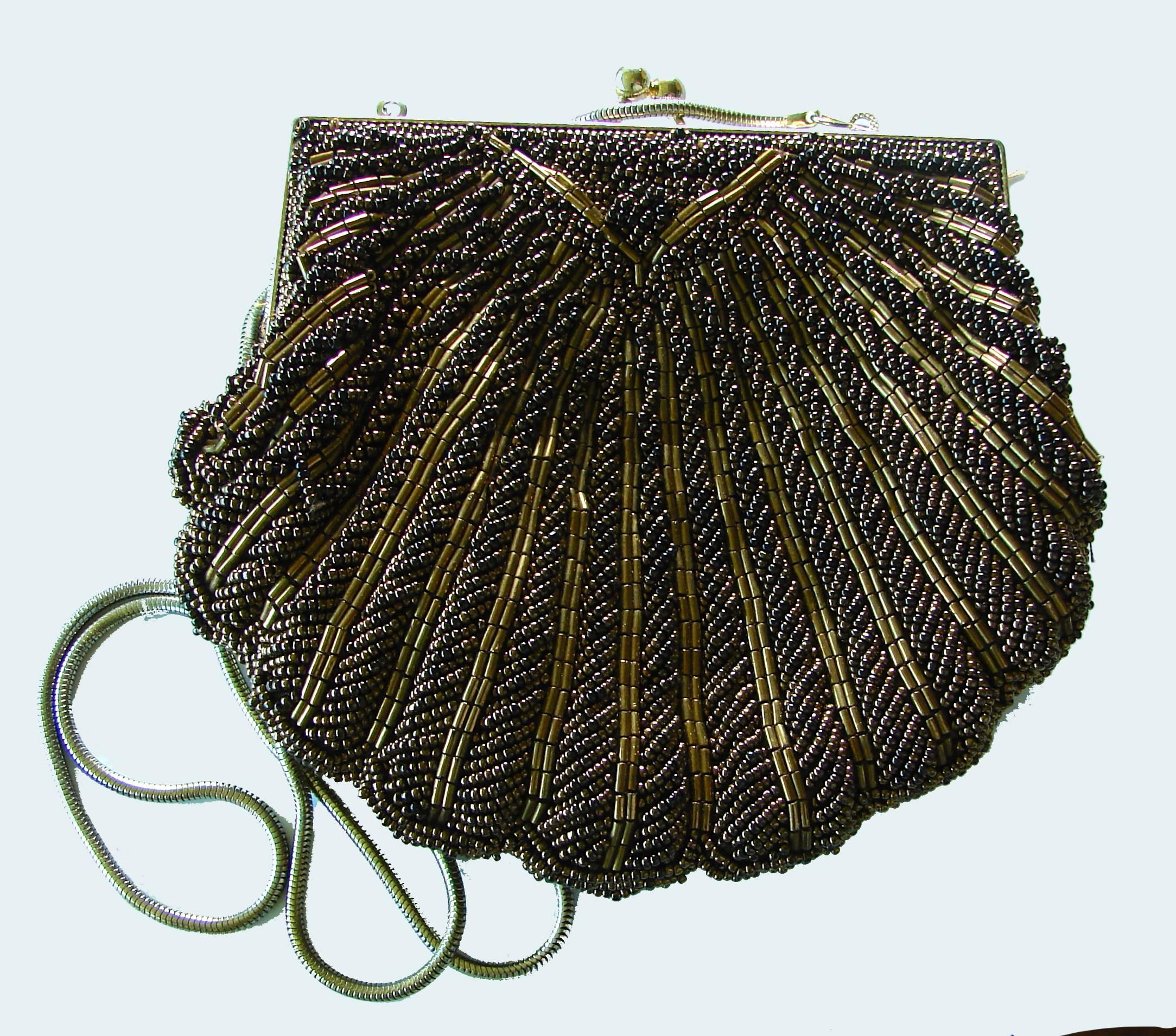 This lovely little evening bag was designed by Walborg in the late 1970s.  It features intricate beading in shades of bronze and brown on the exterior and a rich brown silk satin lining with one small interior pocket.  It fastens with a gold