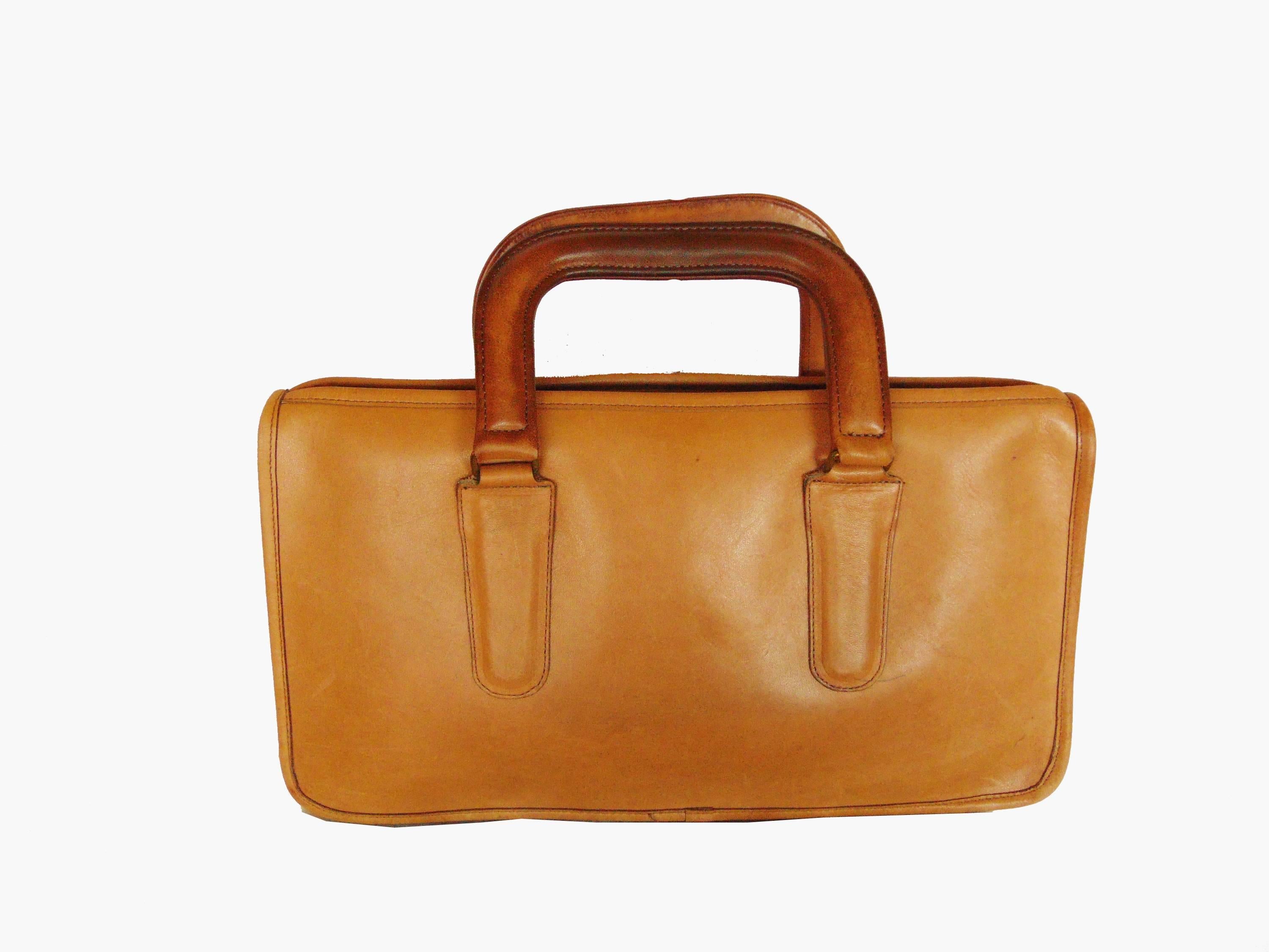 This sturdy zippered leather tote bag was designed in the early 1970s by Bonnie Cashin during her time at Coach Leatherware.  Made from saddle leather, it features a chunky brass zipper and is unlined with one flat pocket inside.  In very good