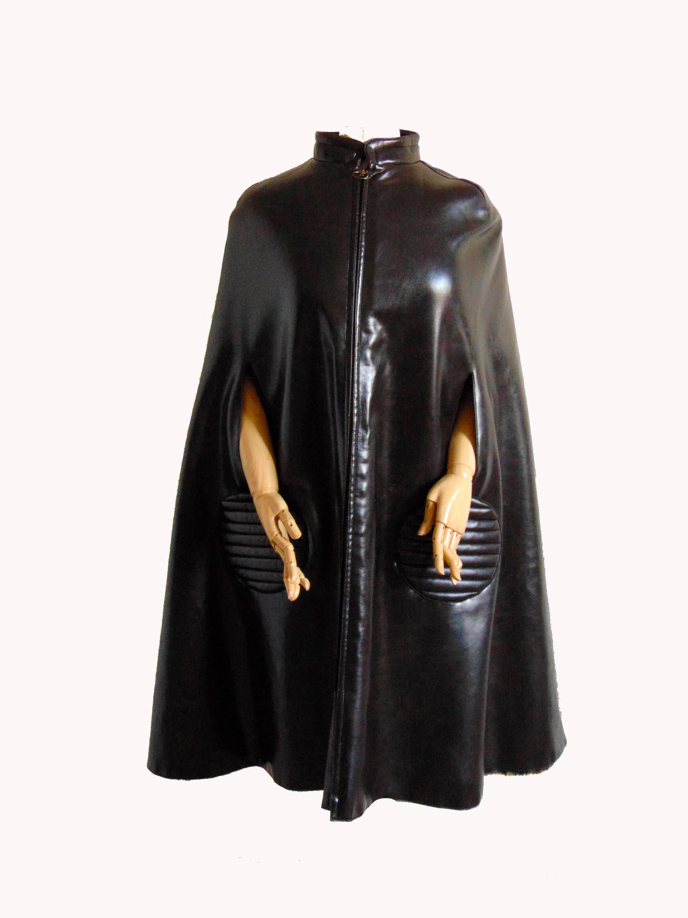 This incredible space age cape was made by Pierre Cardin in the 1960s.  Made from an unusual espresso brown vinyl, it fastens with a chunky brass zipper and pull ring and is fully lined in spotted faux fur.  Each outer pocket features mod quilted