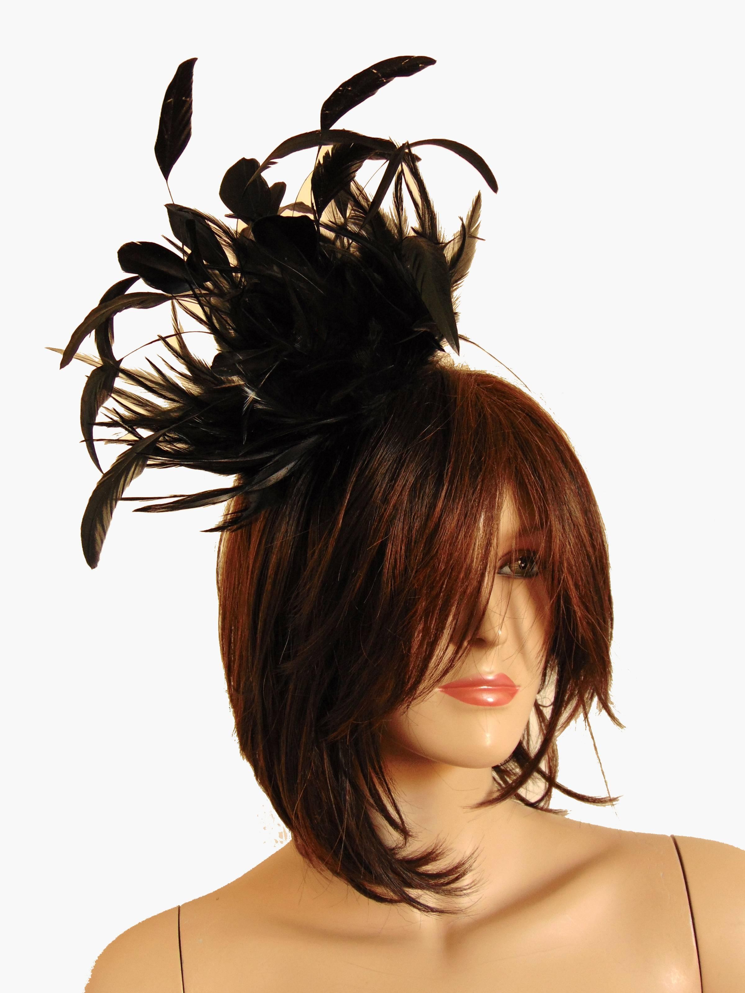 This rare feather cap was made by Yves Saint Laurent in the mid 1970s.  Made from a combination of black ostrich and longer plume feathers, which are affixed to a netted fabric base with attached comb.  A true statement piece that can be worn on top