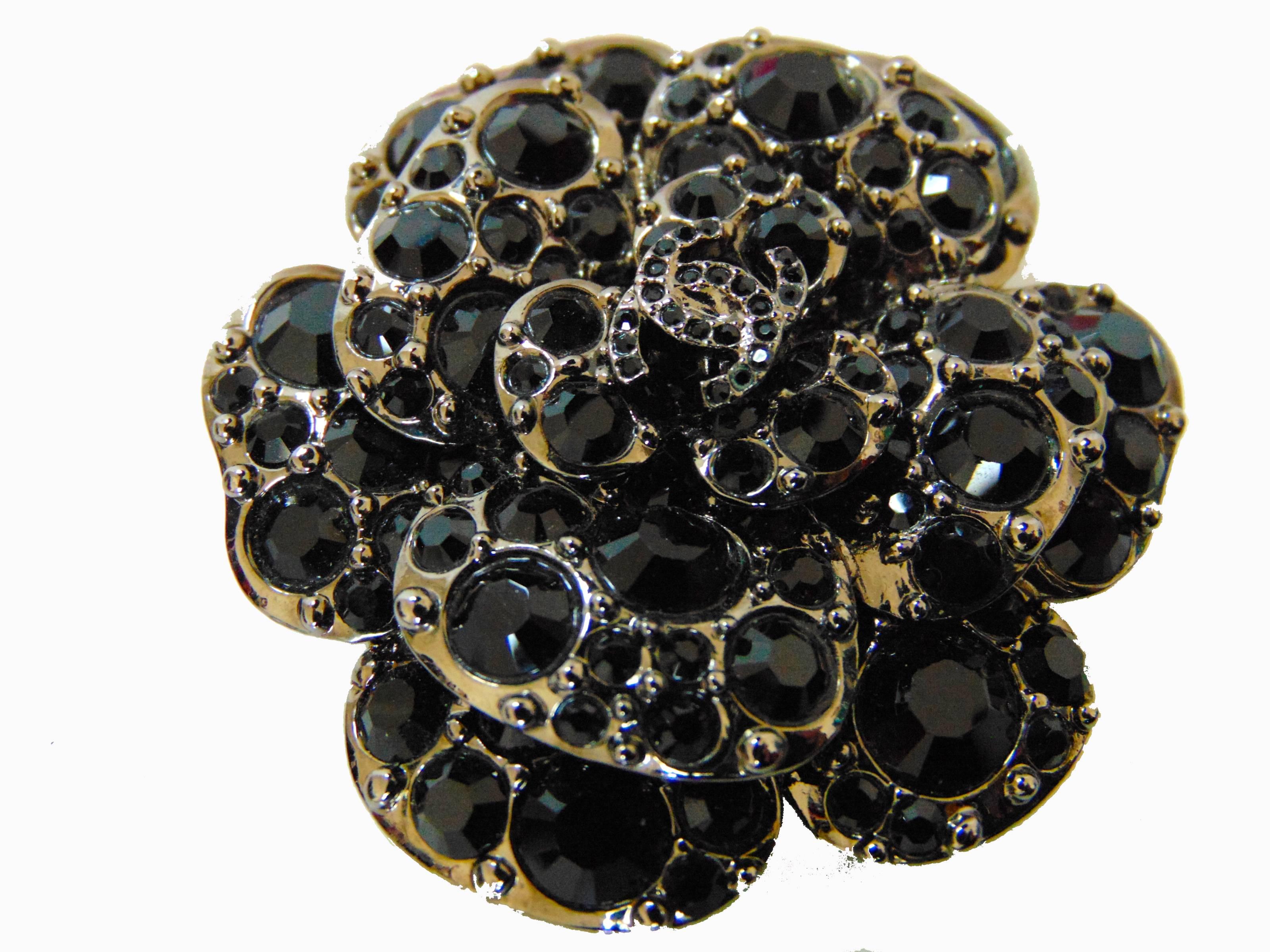 This sparkling brooch or pin was made by Chanel for their 2012 collection.  Hard to find in this color set, it features black crystals against a silver setting.  Fastens in back with bar pin or add it your existing necklace with the attached hook. 