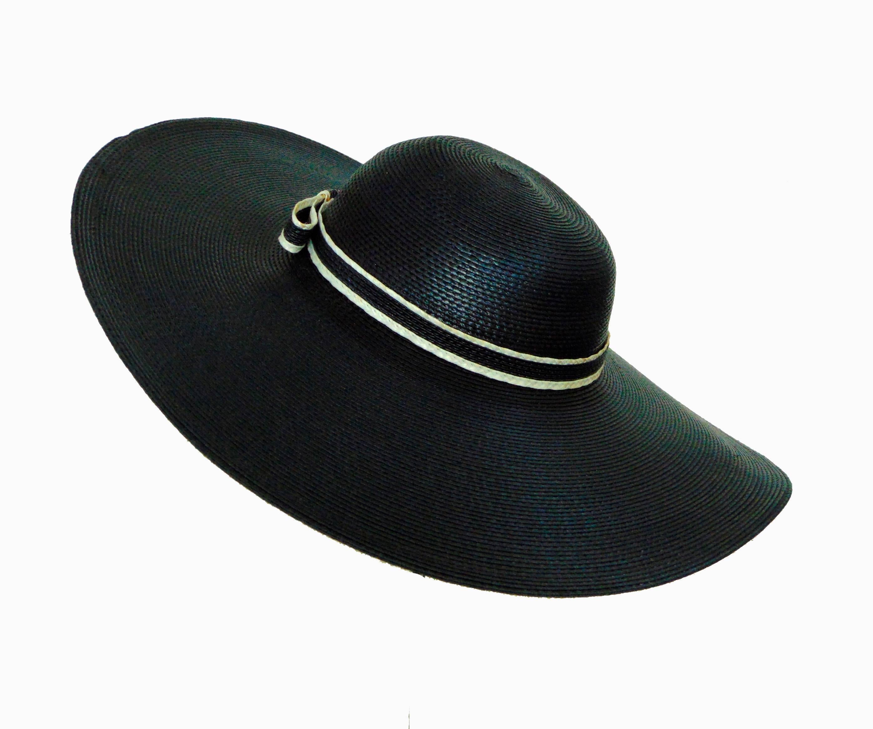 Here's a floppy black straw hat with wide brim by Sylvia New York St. Louis, likely in the late 1960s.  In excellent condition, we note some teensy spots to the contrast ribbon, hard to see unless closely inspecting, and some loose threads to the
