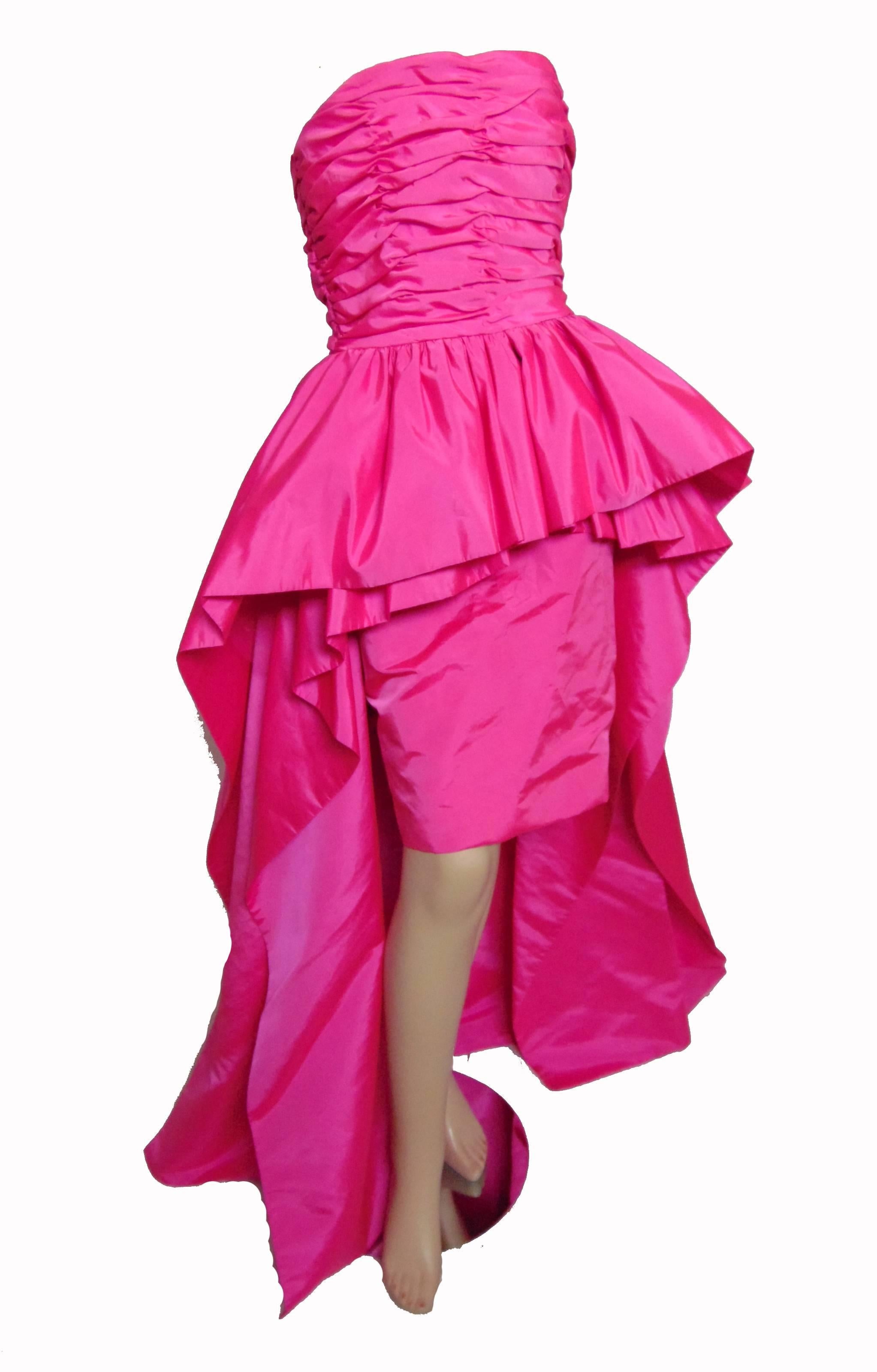 This fabulous evening gown was made by Victor Costa for Saks Fifth Avenue, likely in the late 1990s.  This piece features a sheath base dress with layers of pink taffeta fabric that ruffles at the center and falls to the floor in back! Each layer