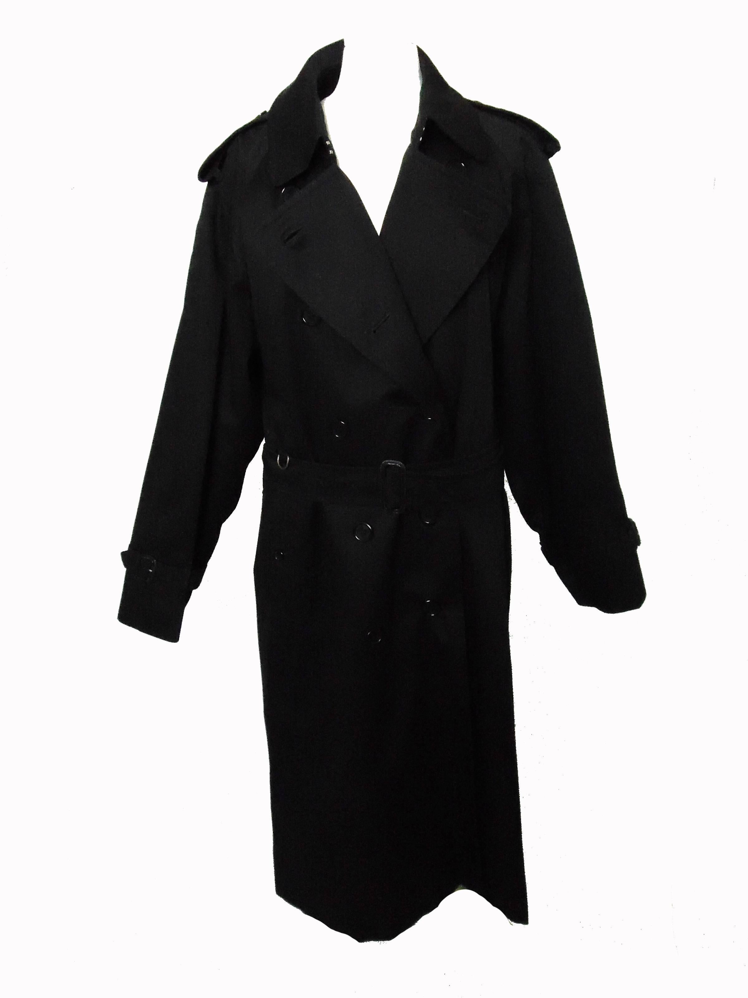 This classic long trench coat was made by Burberry London, most likely in the late 1990s.  Made from black cotton gabardine, this piece is lined in Burberry's iconic check and features a removable black cotton blend warmer.  Comes with its original