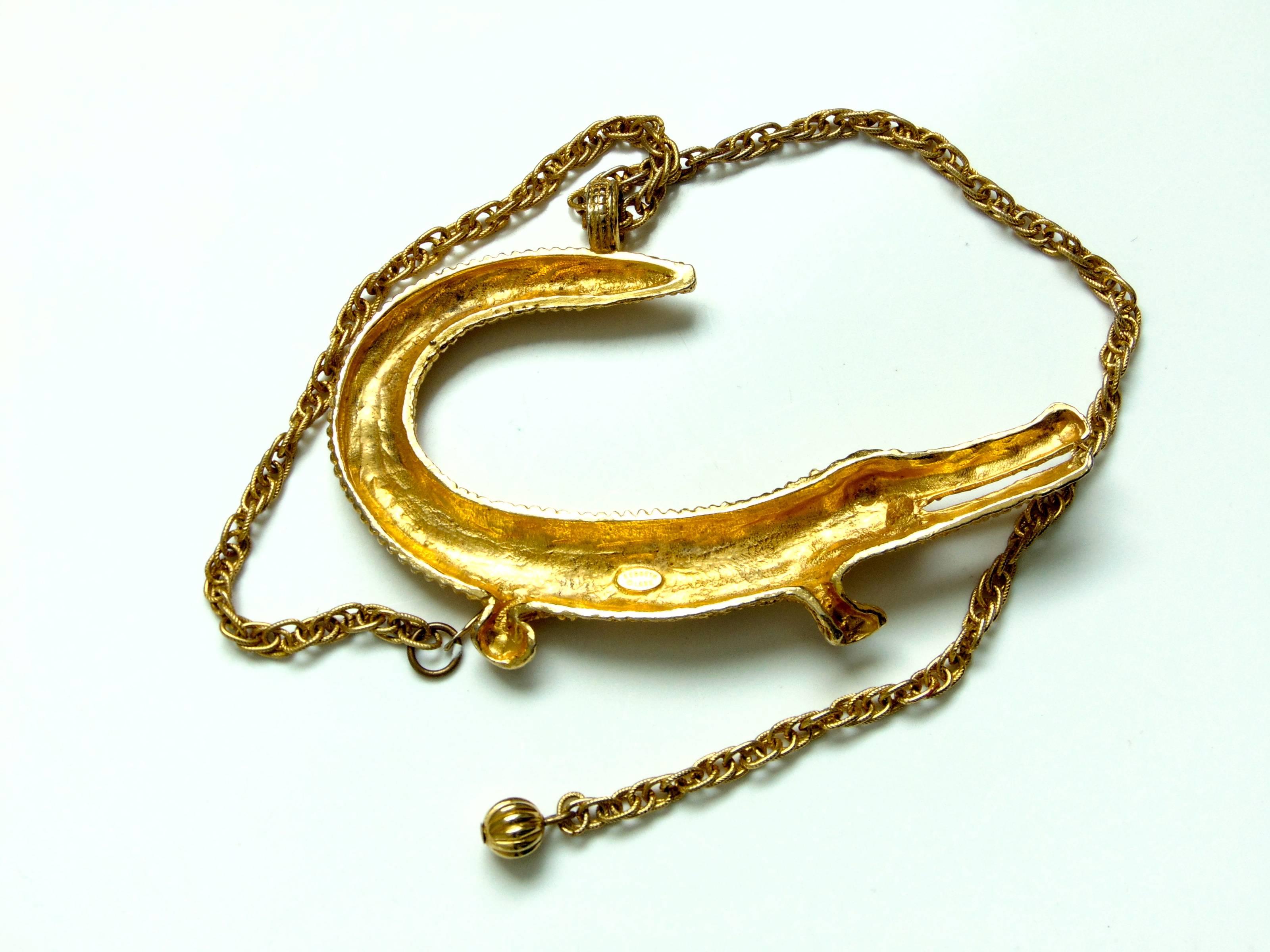 This figural crocodile or alligator choker was made by Kenneth Lane, most likely in the 1980s. Made from gold metal, it measures appx 4.5in long x 3.5in high with a 15in chain.  In very good condition with some minor wear to the gold metal finish,
