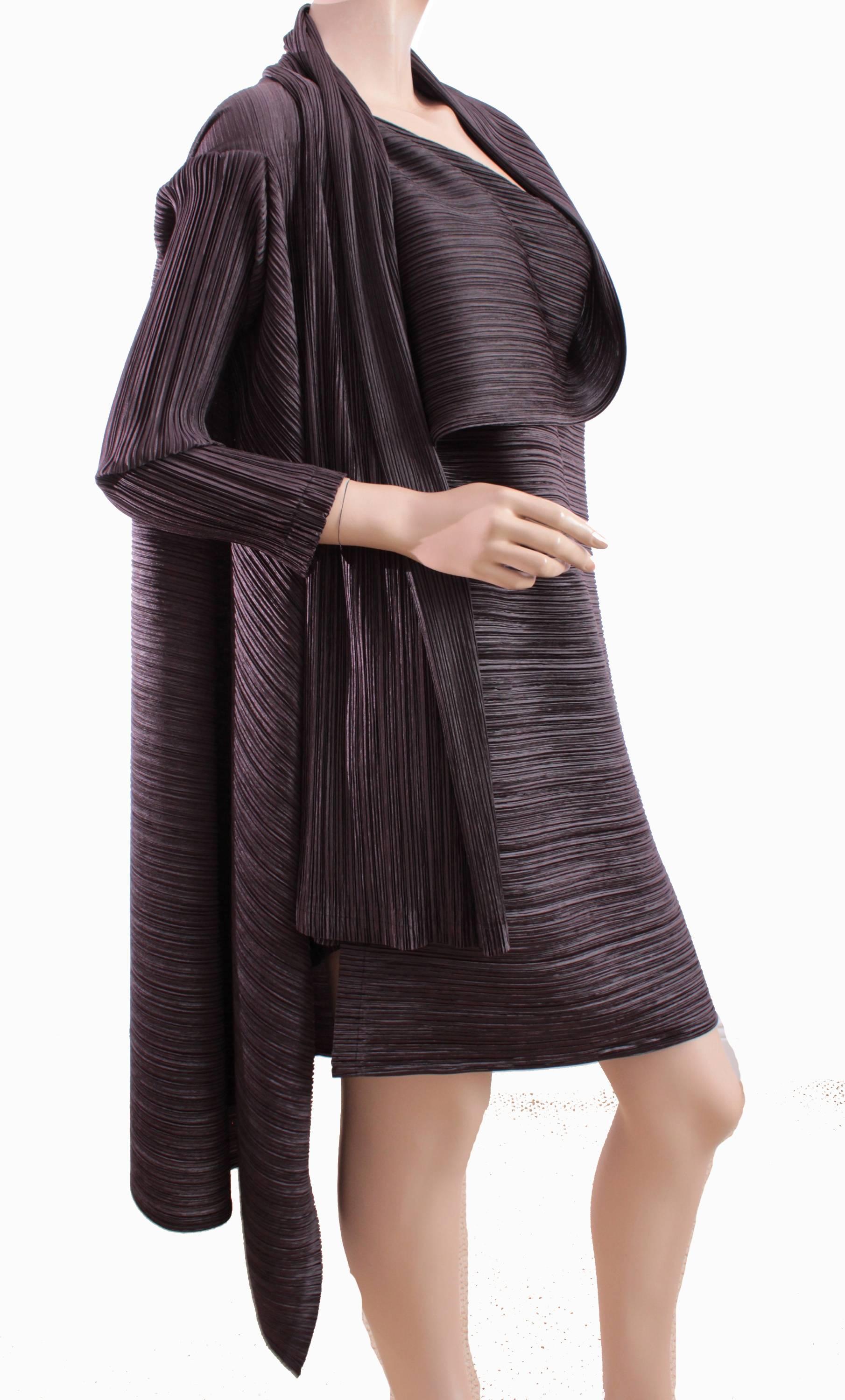 This incredible jacket was made by Japanese designer ISSEY MIYAKE, likely in the early 2000s. It features his signature pleating in a shimmering brown poly fabric, and features two buttons at the shoulders which allow you to drape in several ways.