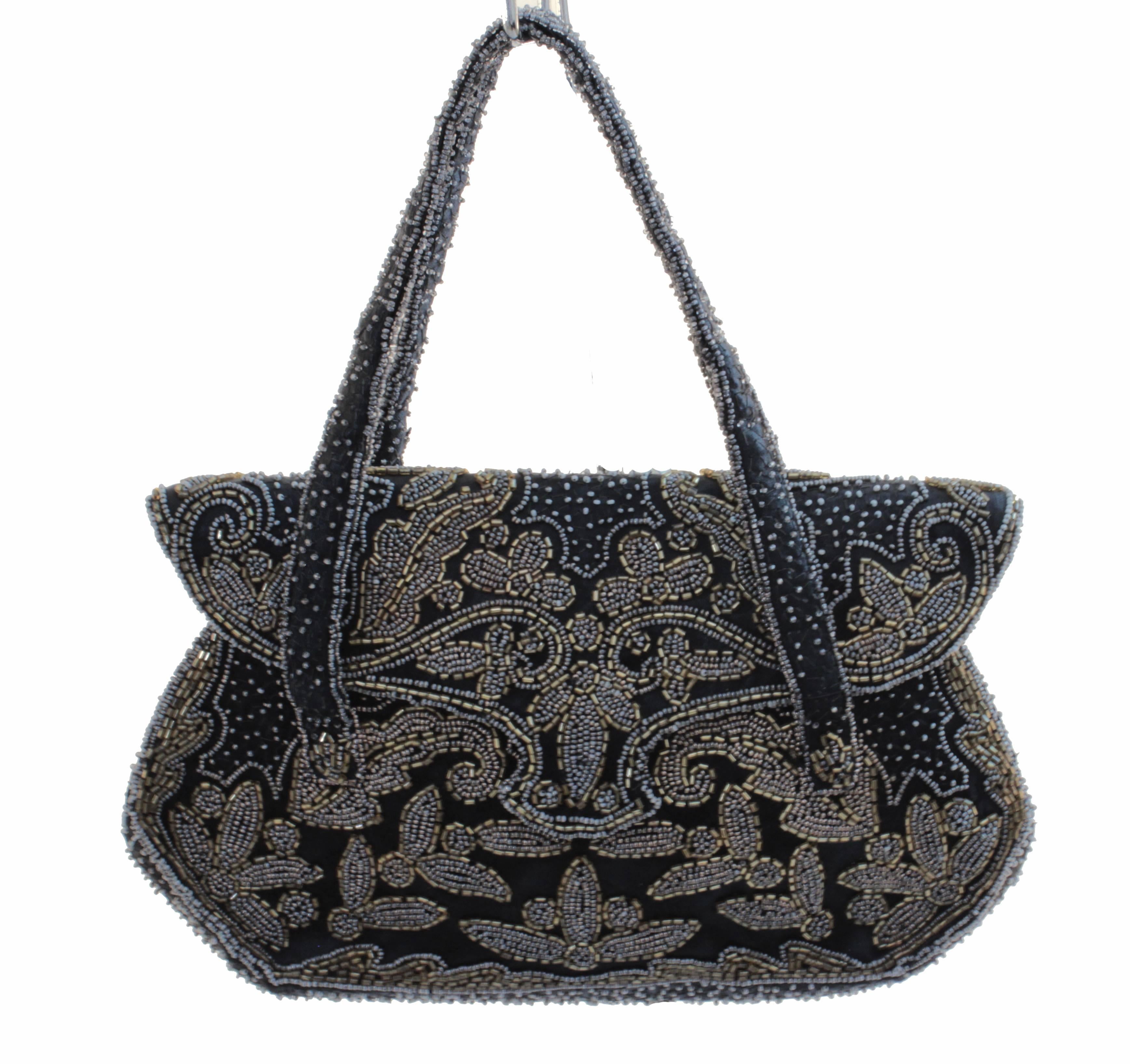 This pretty little evening bag was made in France for Saks Fifth Avenue, most likely in the late 1940s.  Made from black silk, it features gold bugle and tiny white pearl beads throughout.  It's fully-lined in black silk and features one flat