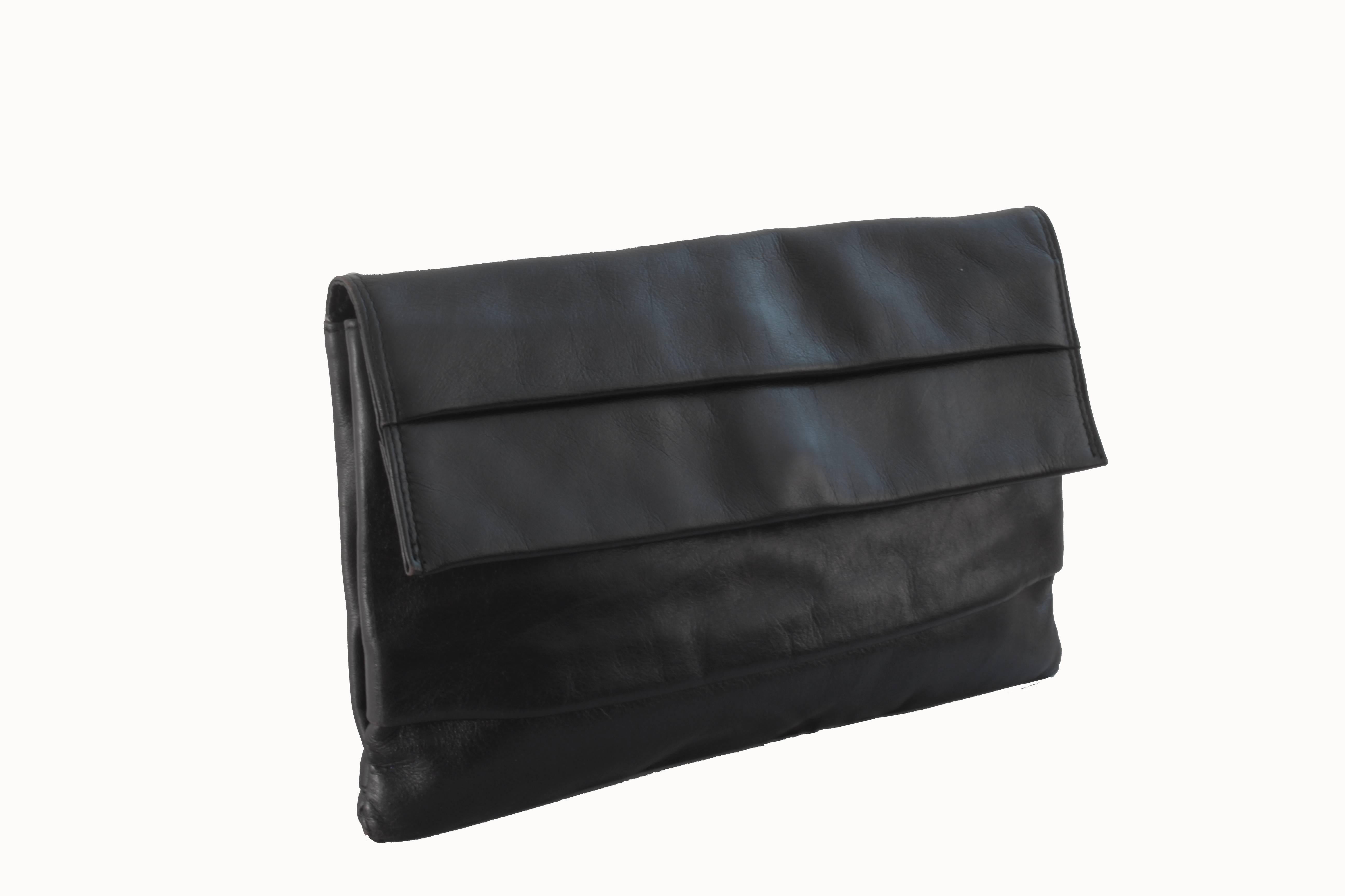 This classic black leather clutch bag was made in Italy for Dayton's Department Store, most likely in the early 60s, before they merged with JL Hudson company. Simple in it's design, it fastens with a magnetic snap under the top flap and features