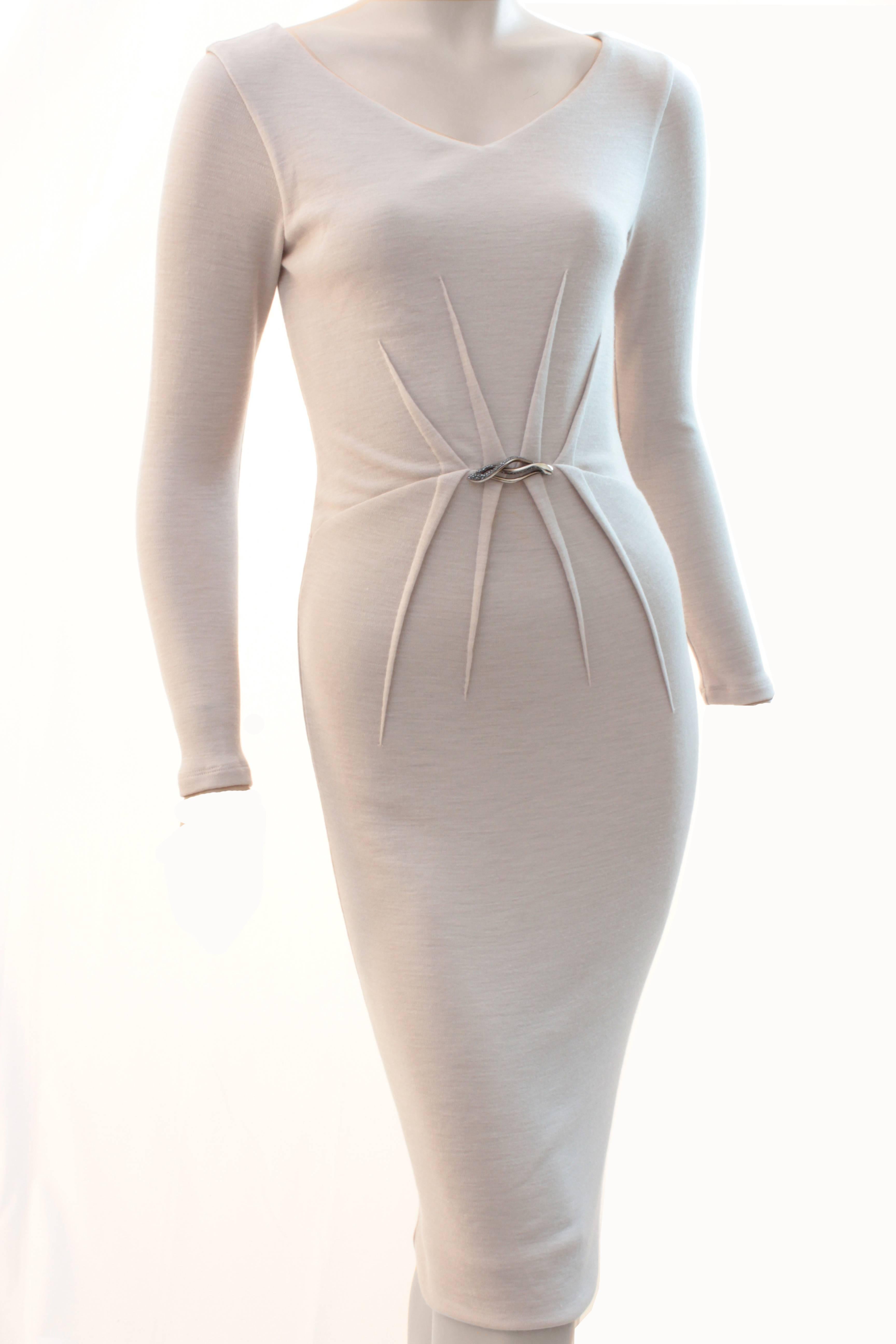 Here's a sexy little dress from Roberto Cavalli! Made from a creme colored wool/polyamide blend knit, it features a v-neck, a cinched waist with sewn-in pleating detail and a silver and rhinestone embellished piece in front.  Fully-lined, it fastens