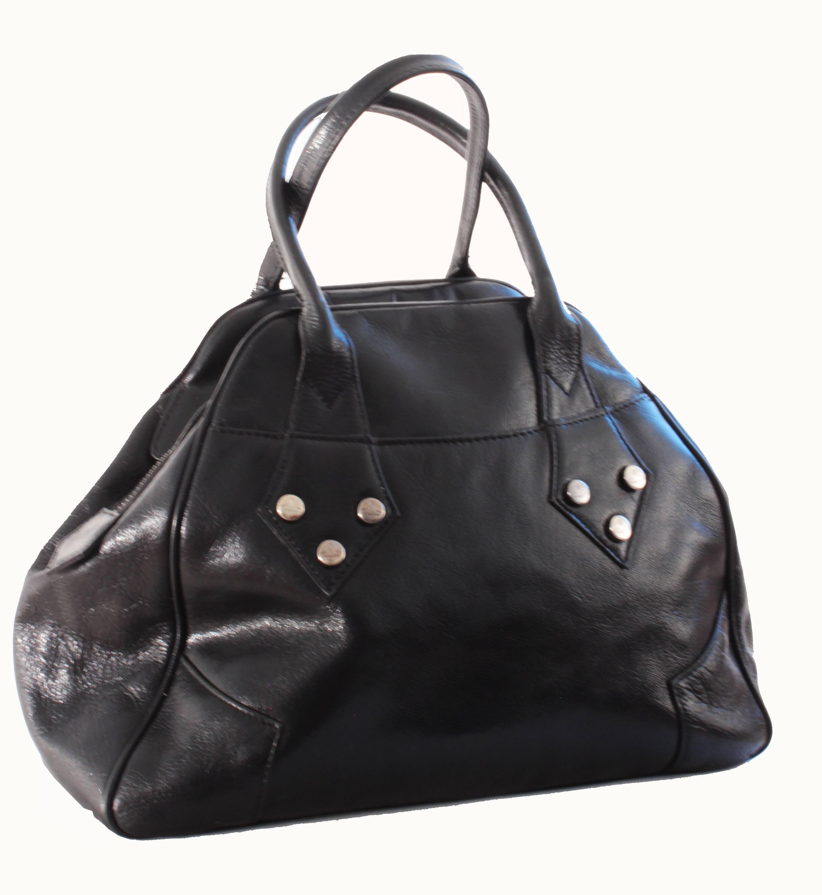 This black leather bag was made by Vivienne Westwood, most likely in 2000.  With it's bowler style shape, if features silver hardware that's embossed with the Westwood orb, double handles, and a zipper fastener with decorative metal pull with Orb