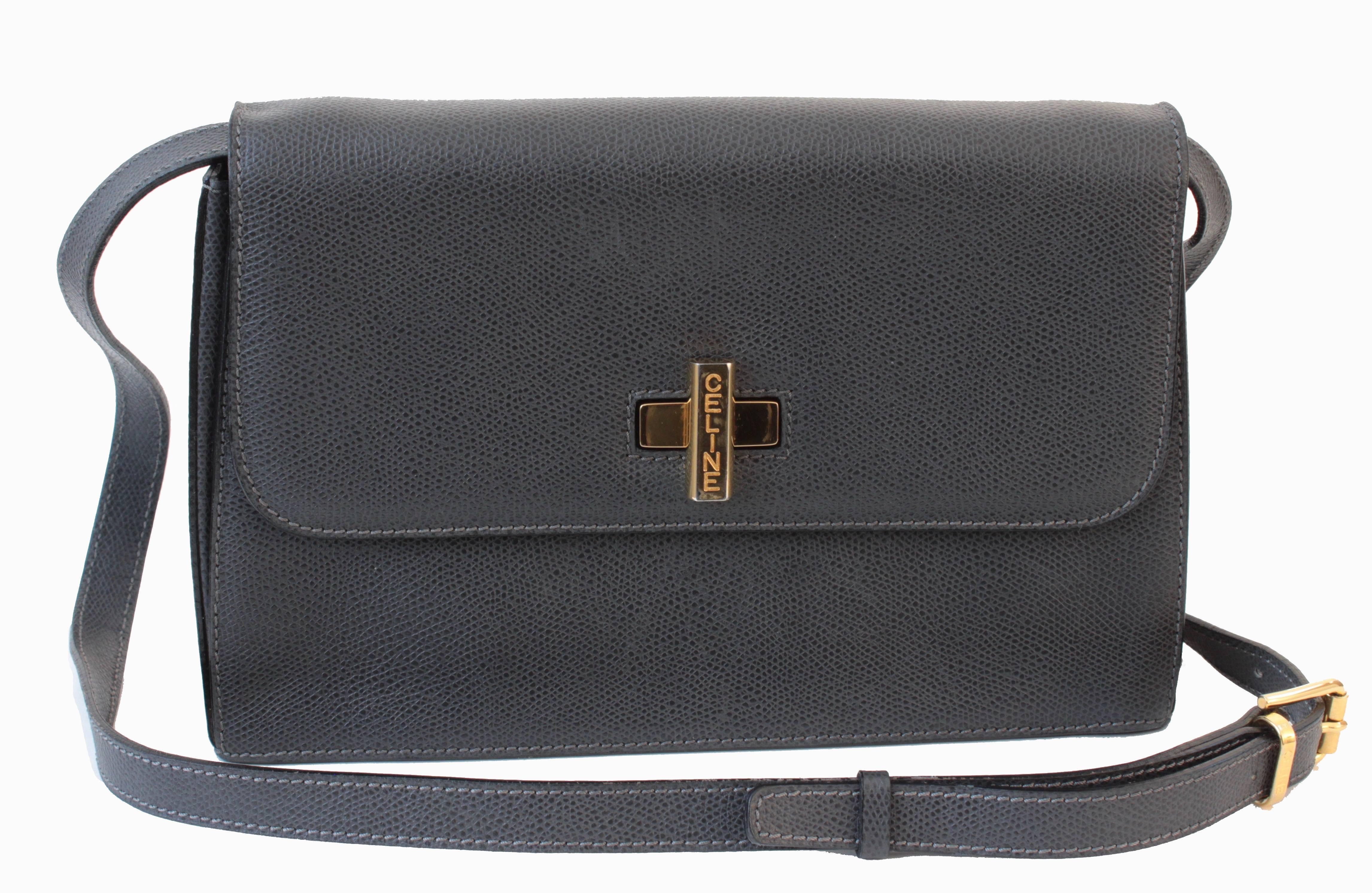 This leather shoulder bag was made by CELINE PARIS, likely in the early 1990s.  Made from a caviar textured leather in steel gray, it features a gold logo turn lock fastener, an adjustable shoulder strap, and accordion style pockets inside, all
